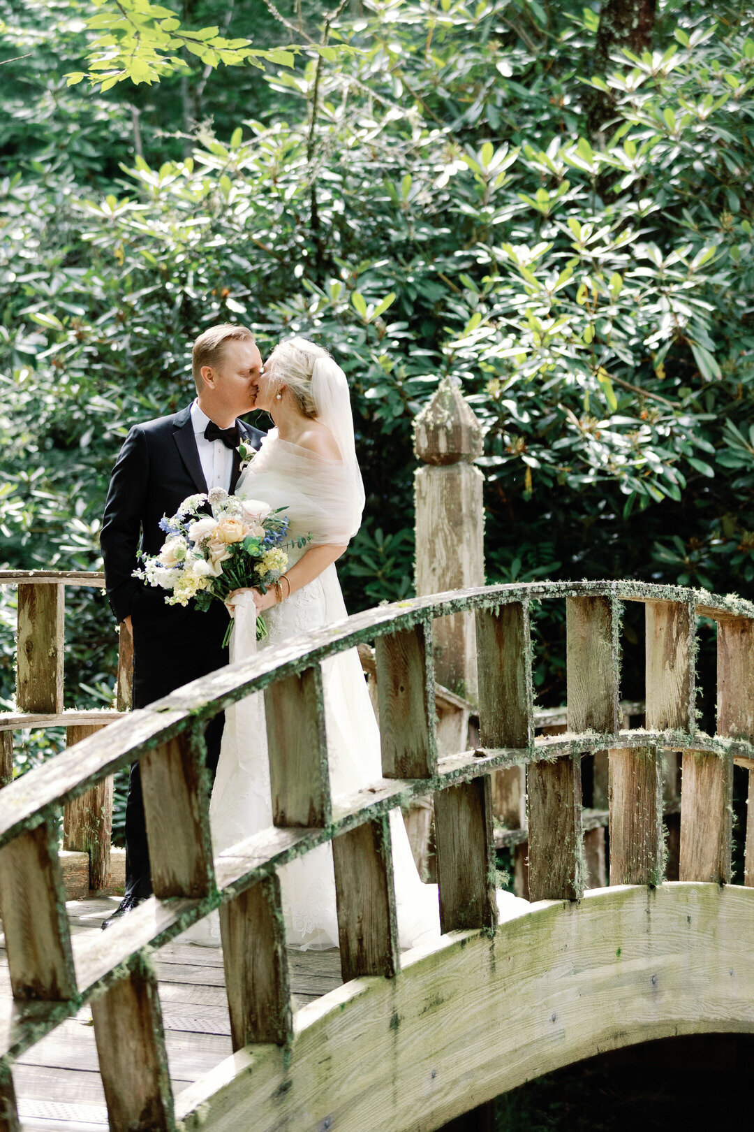 Bride and Groom kissing on bridge at The Farm at Old Edwards