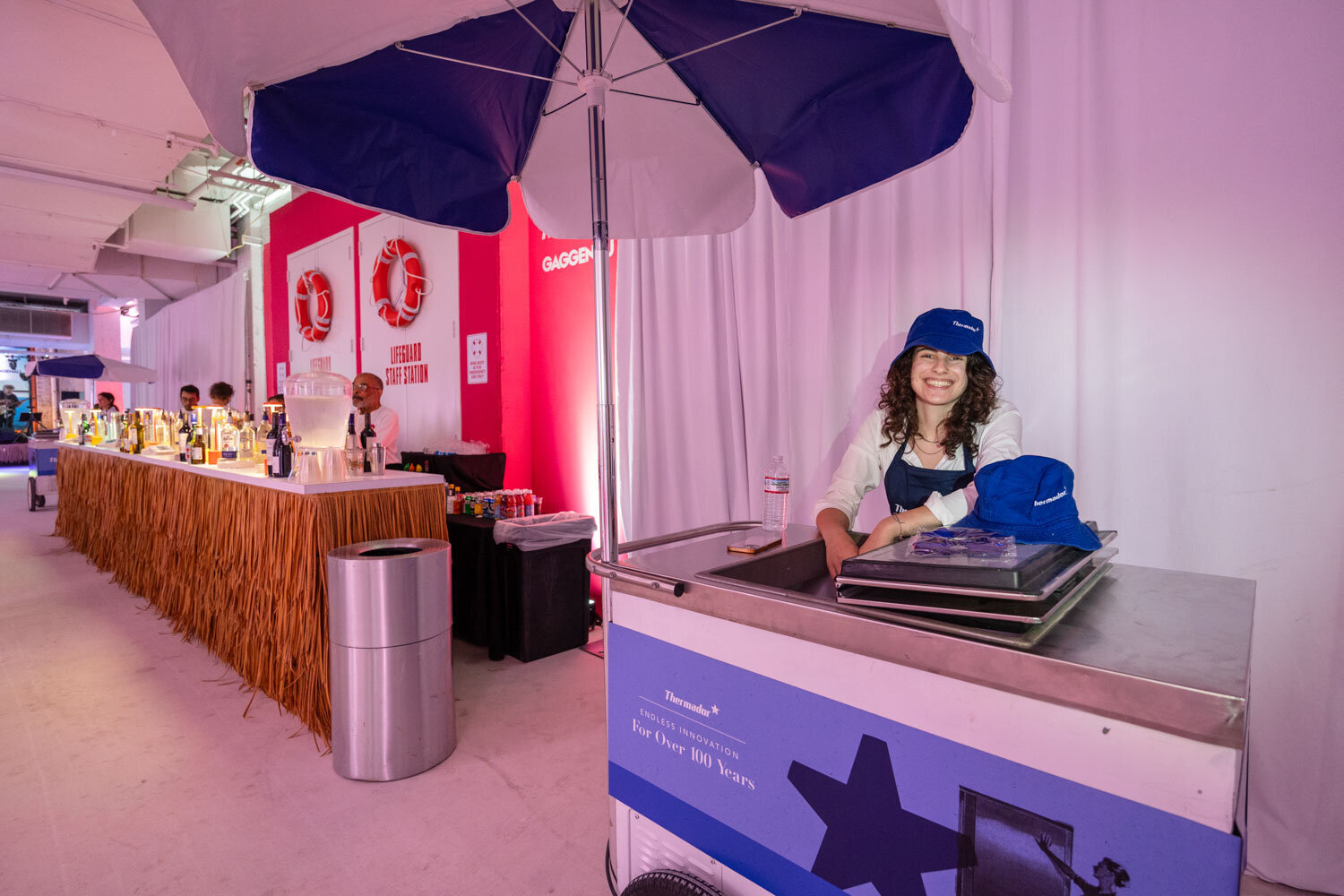 Ice cream booth setup with smiling attendant under umbrella