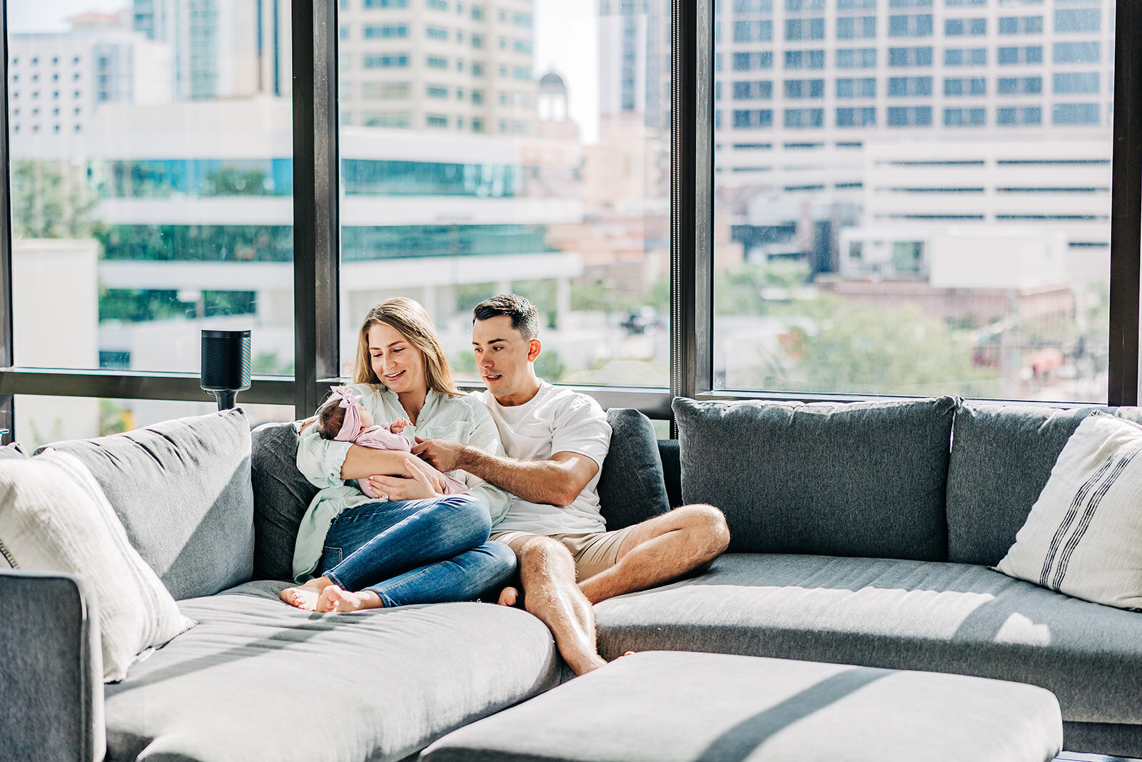 A photo of new mom and dad with thier newborn girl in thier apartment near st. pete fl