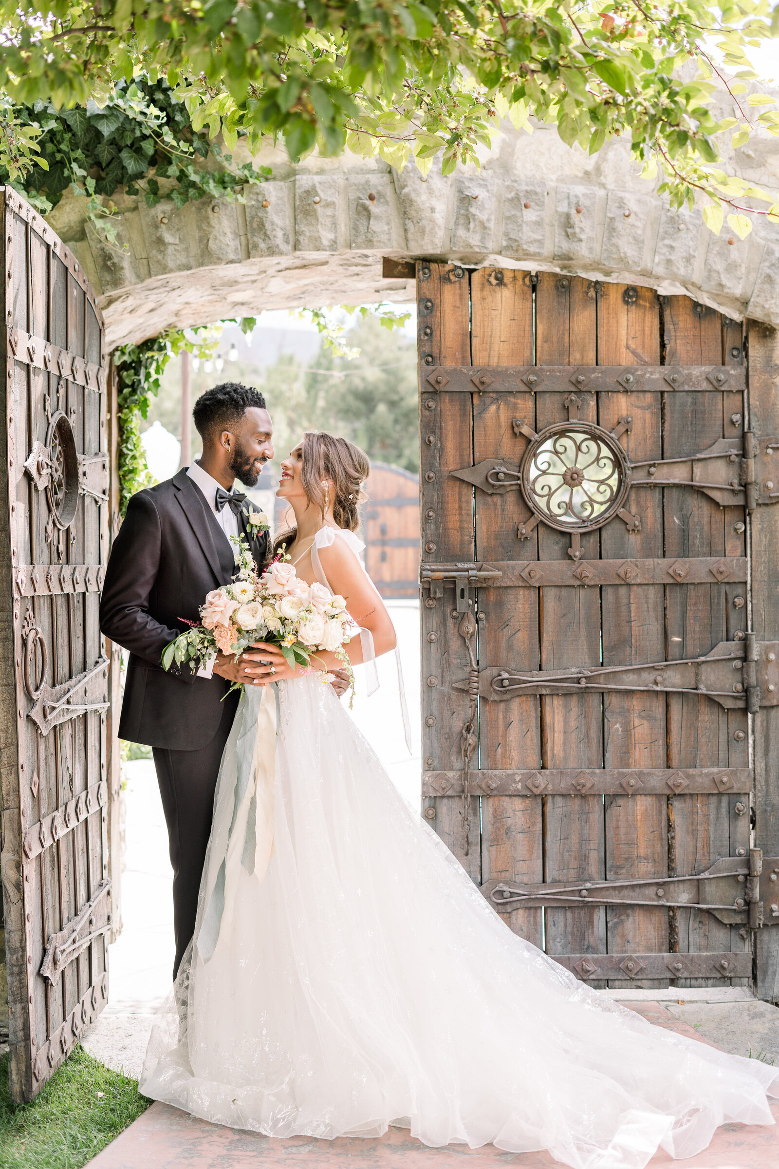 a bride and groom pose for their couples portraits at their napa winery wedding by adrienne and dani photography, napa wedding photographers