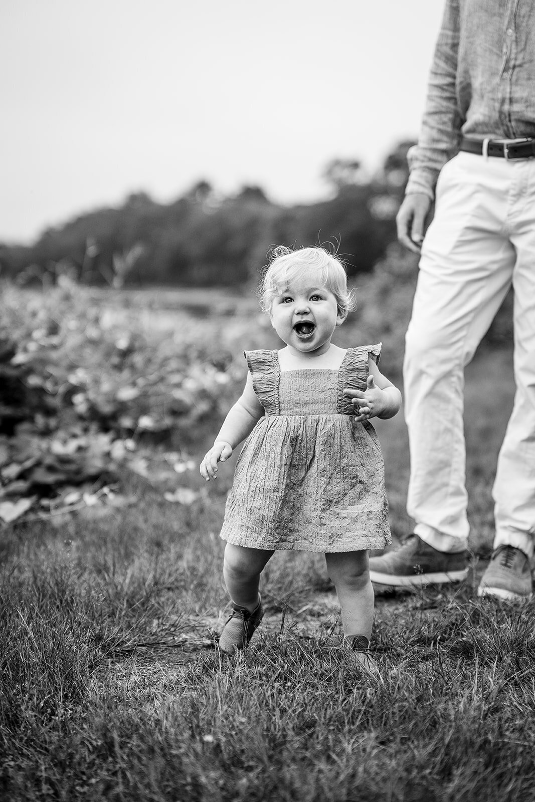 one year old baby laughs and walks towards camera