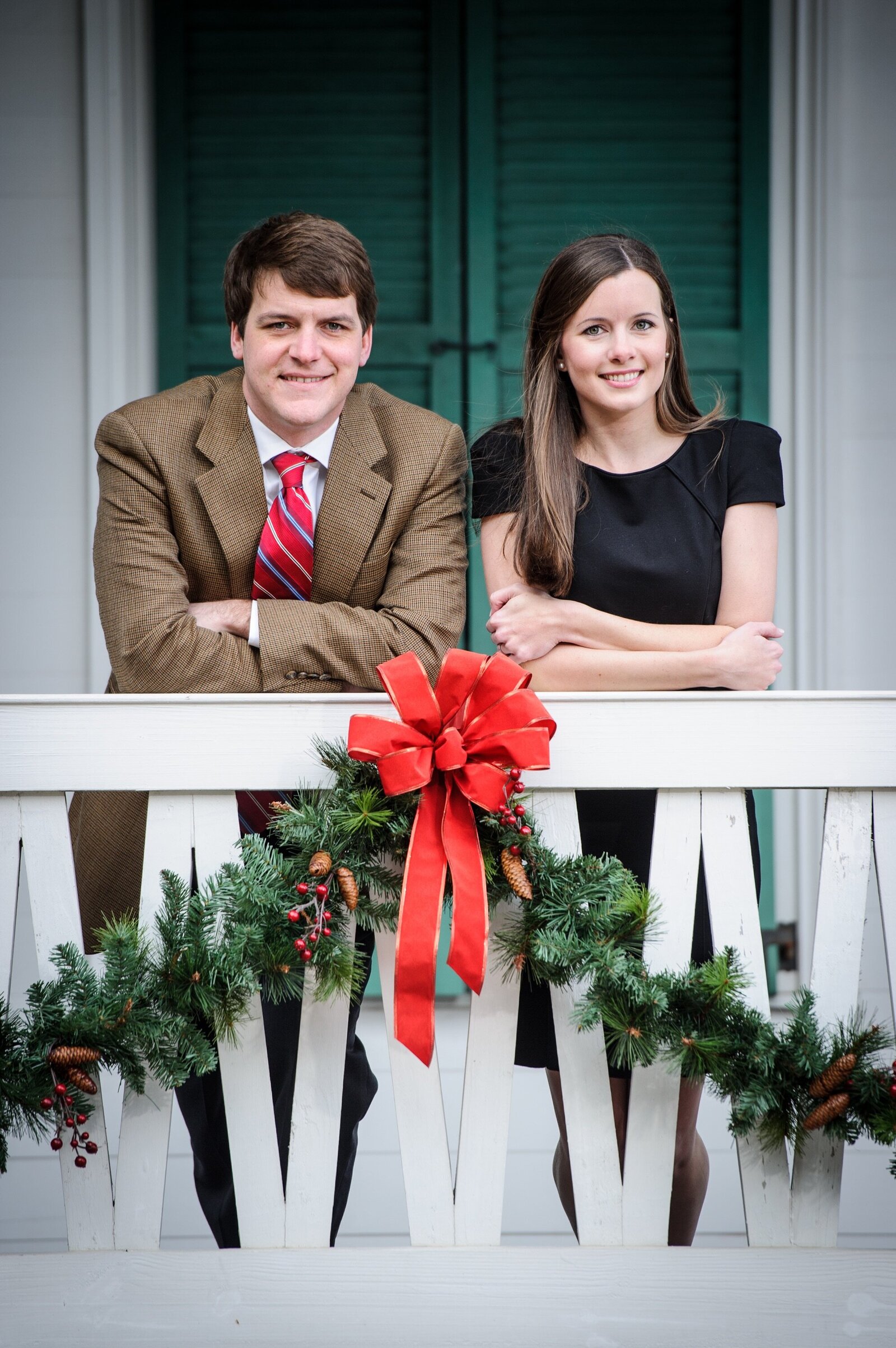 Engagement portrait in Gulfport Mississippi of couple leaning against railing at Grass Lawn