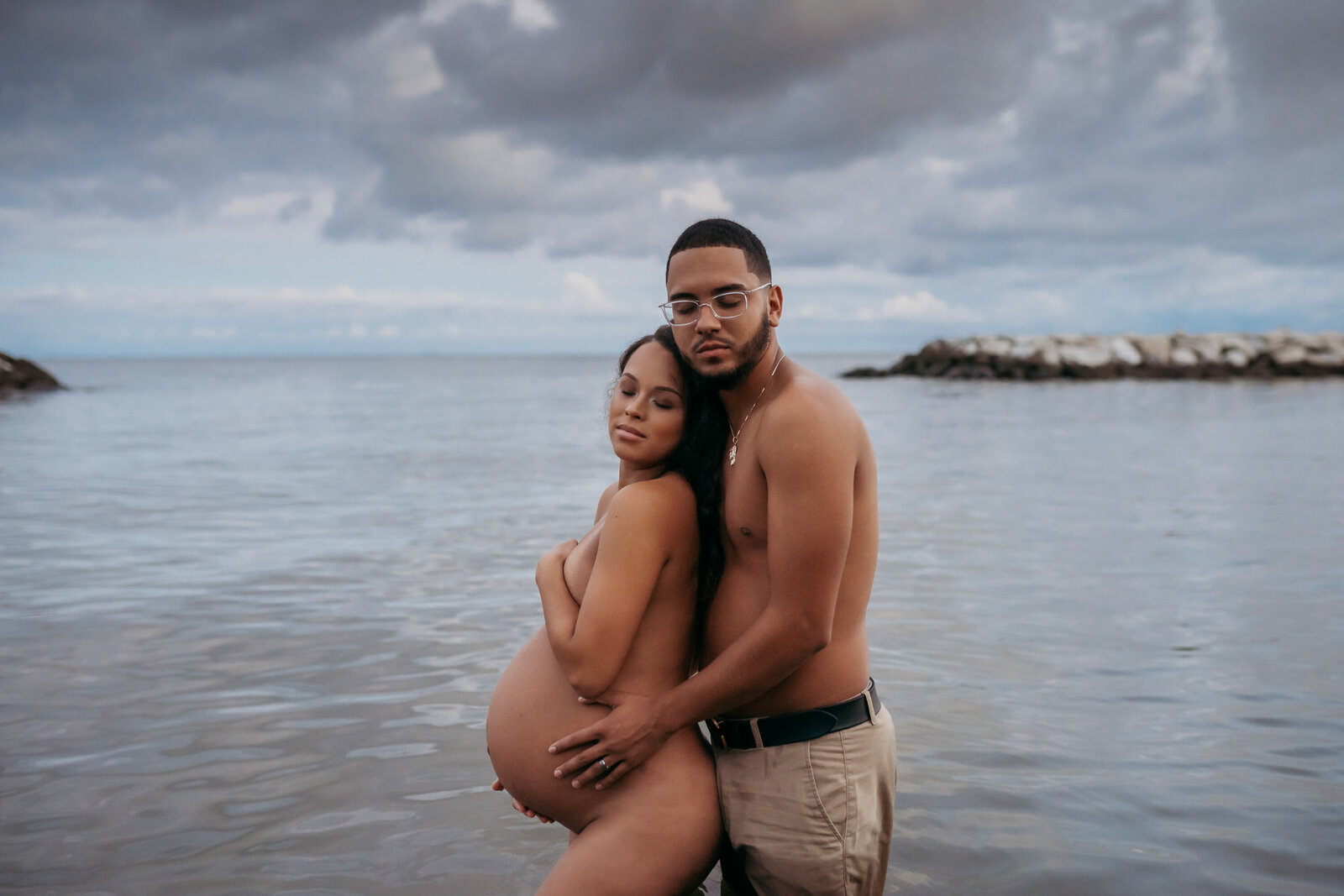 mom and dad in water at beach for maternity session in Tampa