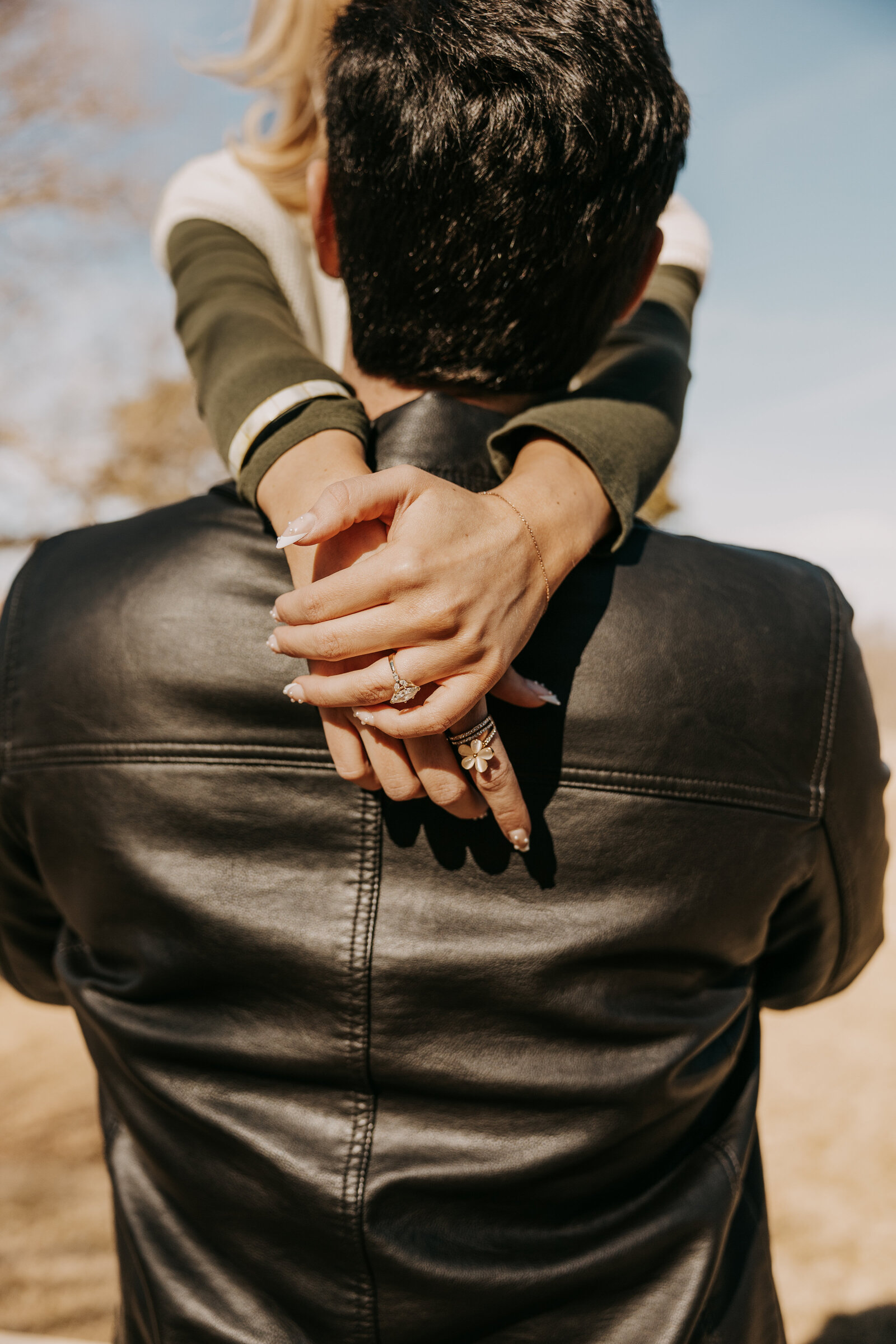 Engagement session with Rachel and Blaine in Oxford, Mississippi, with her hands over his shoulders, focusing on her engagement ring.