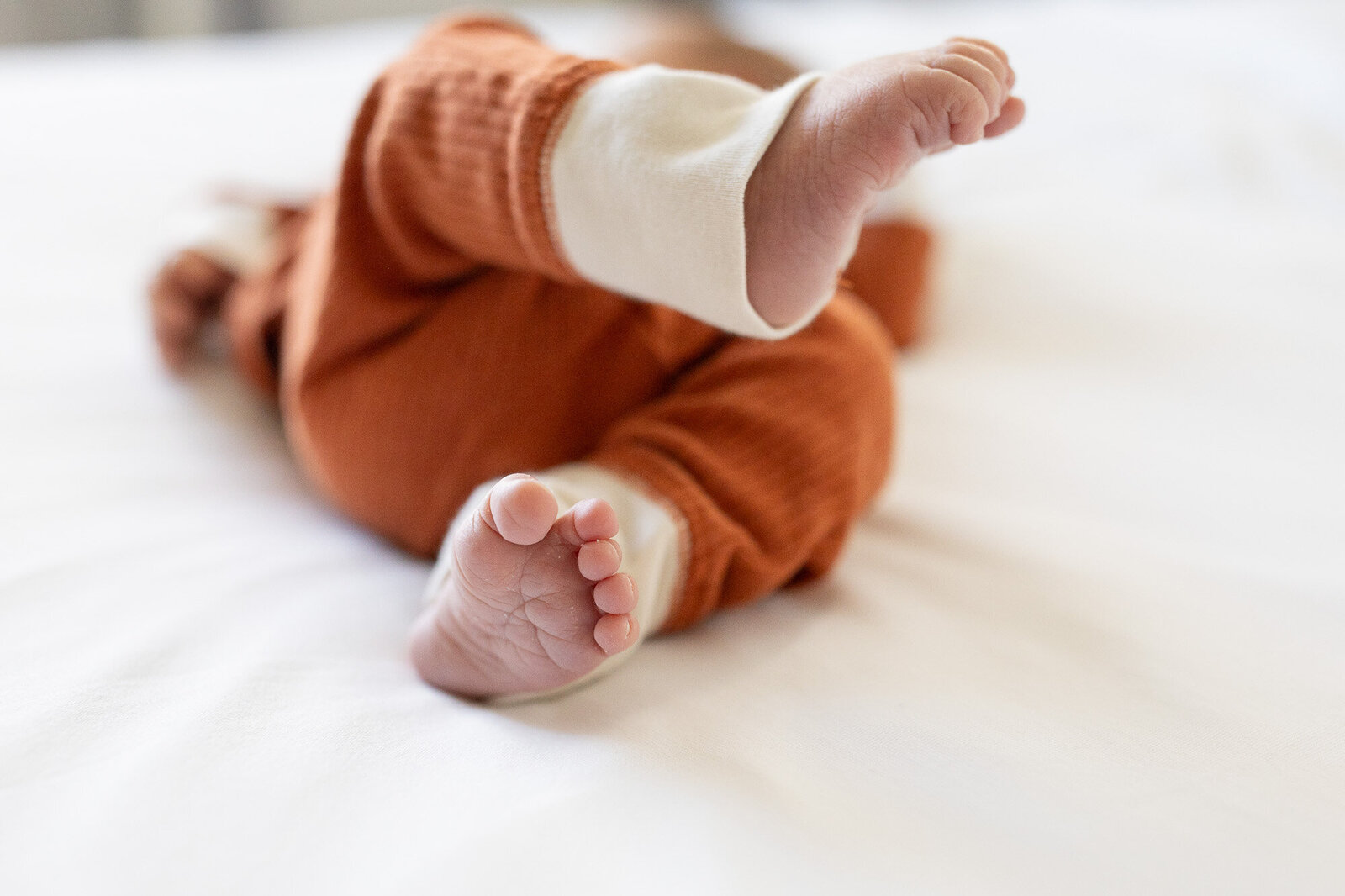 Newborn babies feet on white bedding.