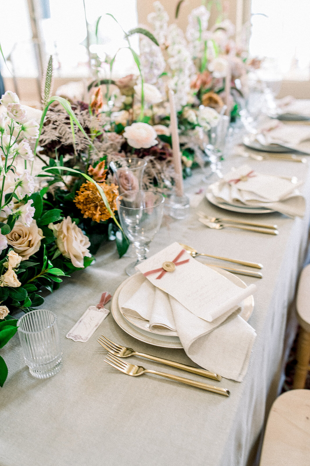An exquisite table setting at the Filoli wedding reception, showcasing elegant floral arrangements and luxurious details in Woodside, California.