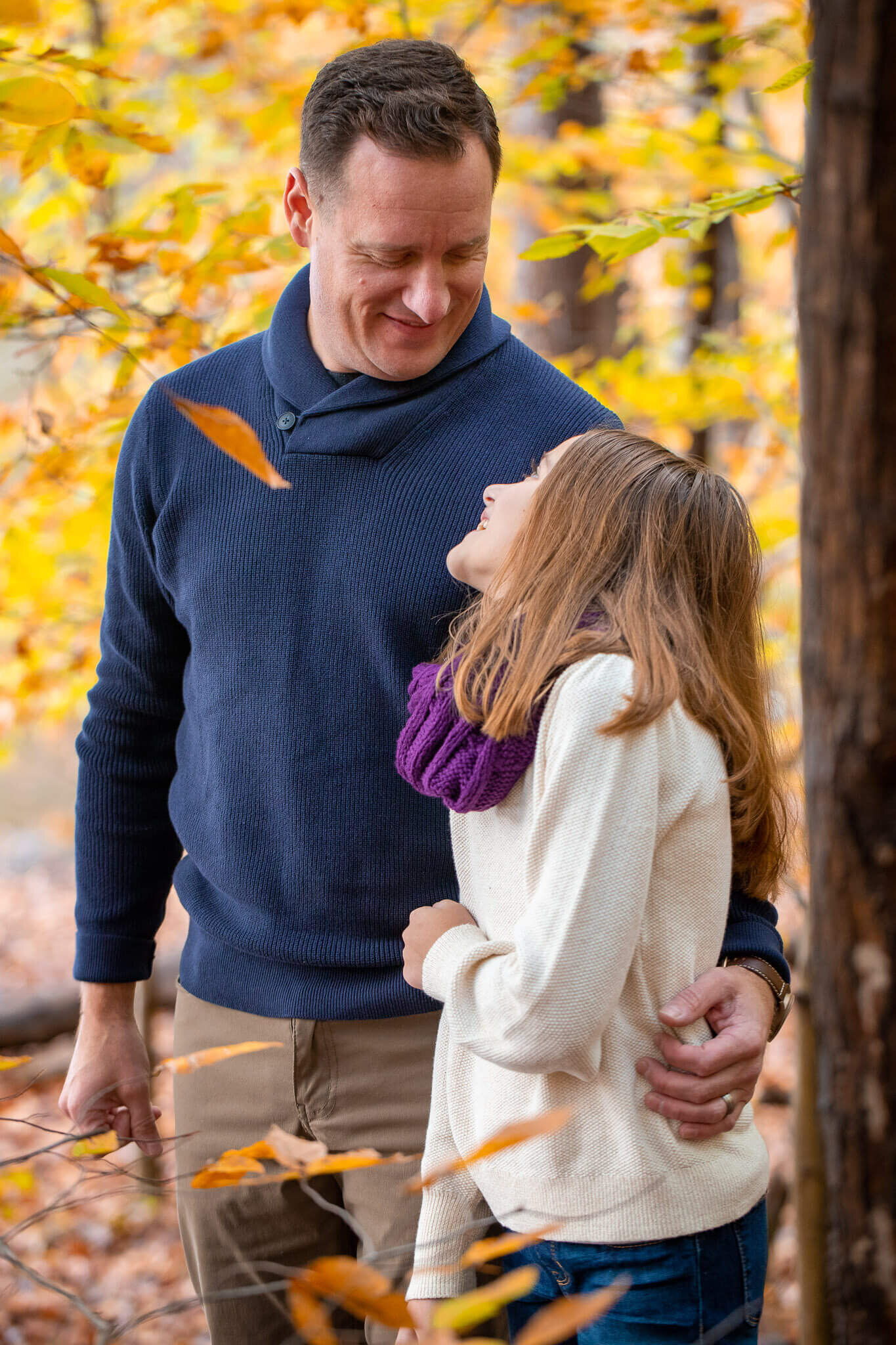 A dad and daughter smiling at each other at a park in Springfield, Virginia.