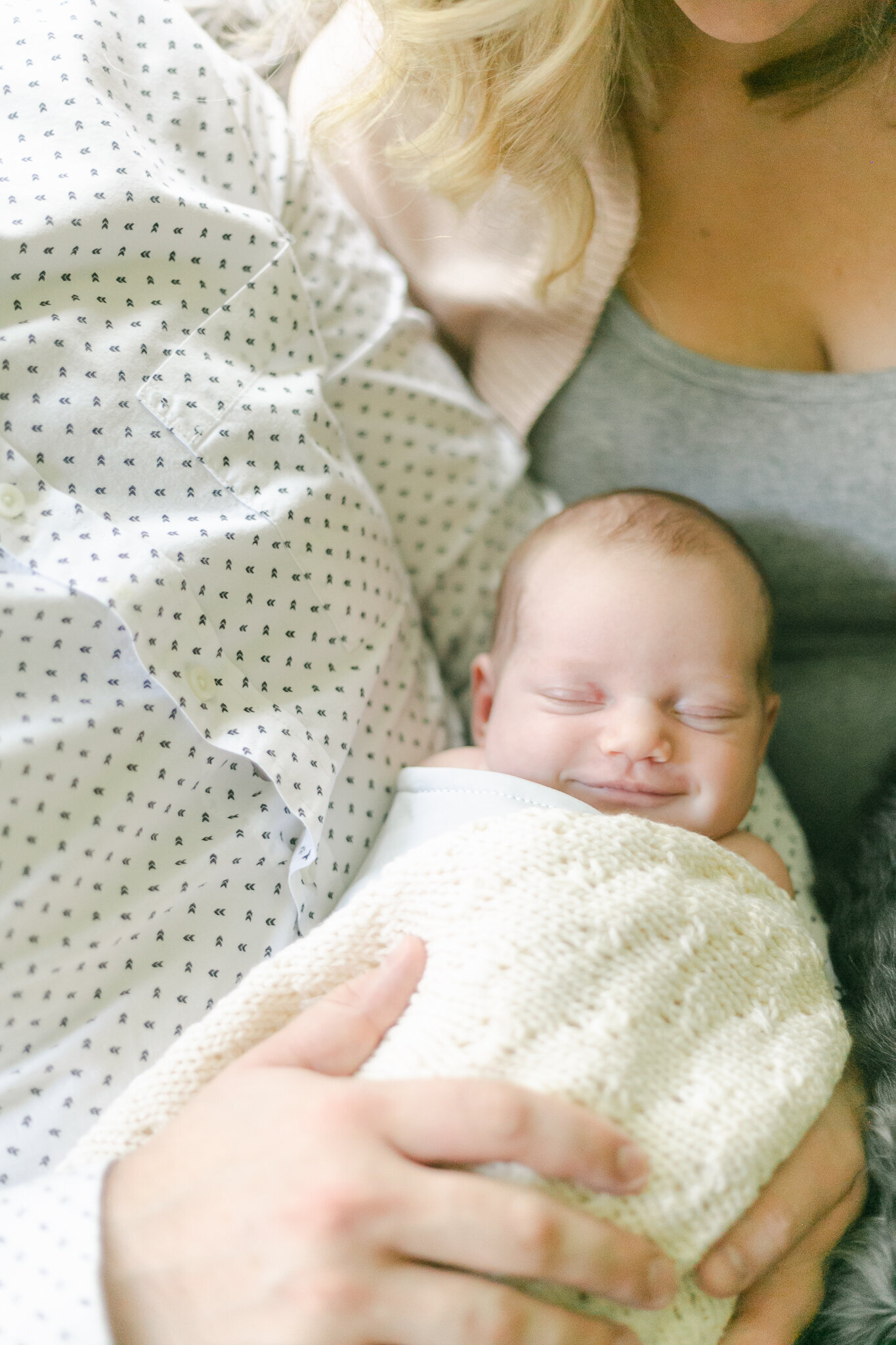 A newborn baby smiles during an in-home Rochester NY newborn photography session.
