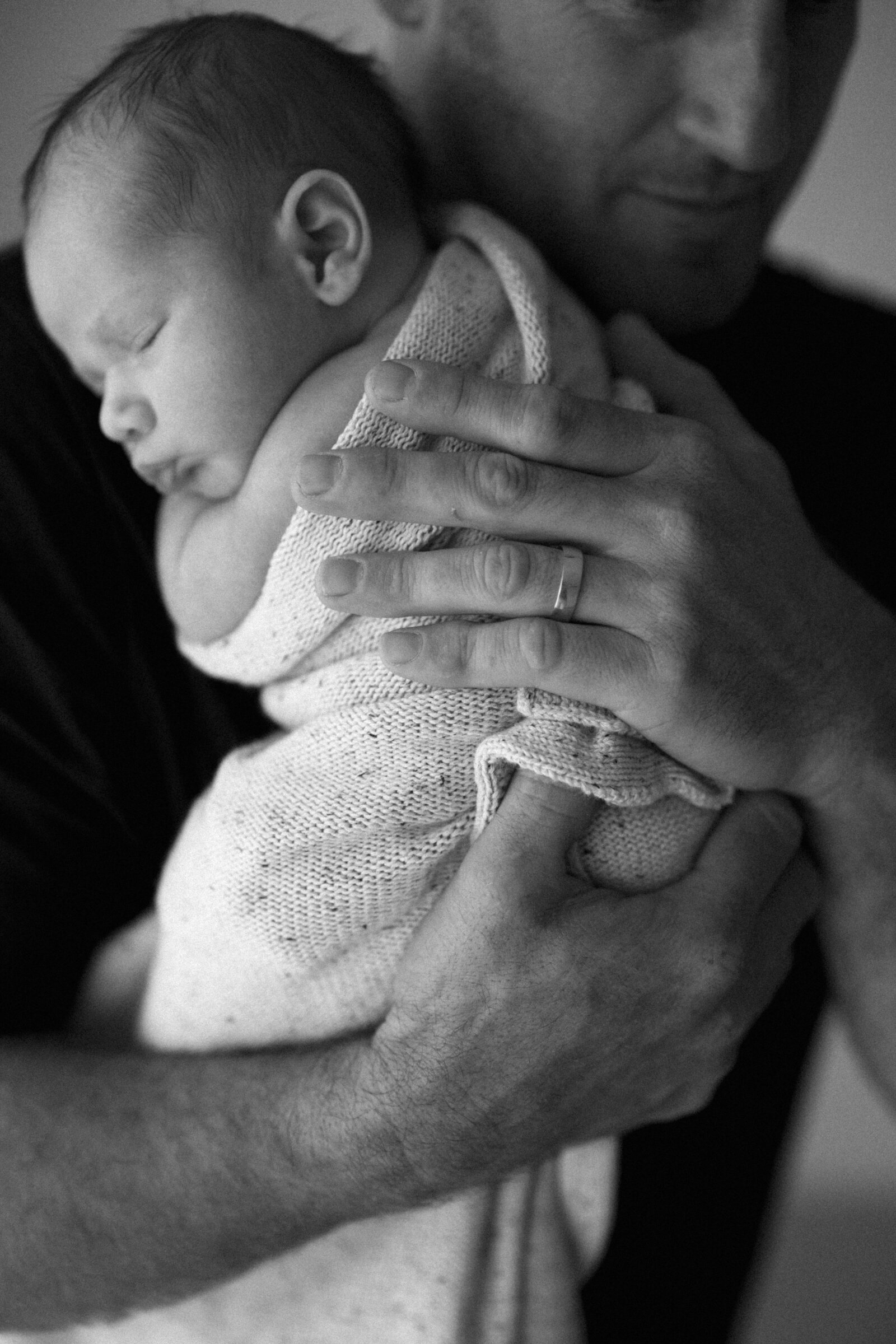 Gentle and intimate newborn family photoshoot in Perth, featuring warm studio lighting and timeless family moments.