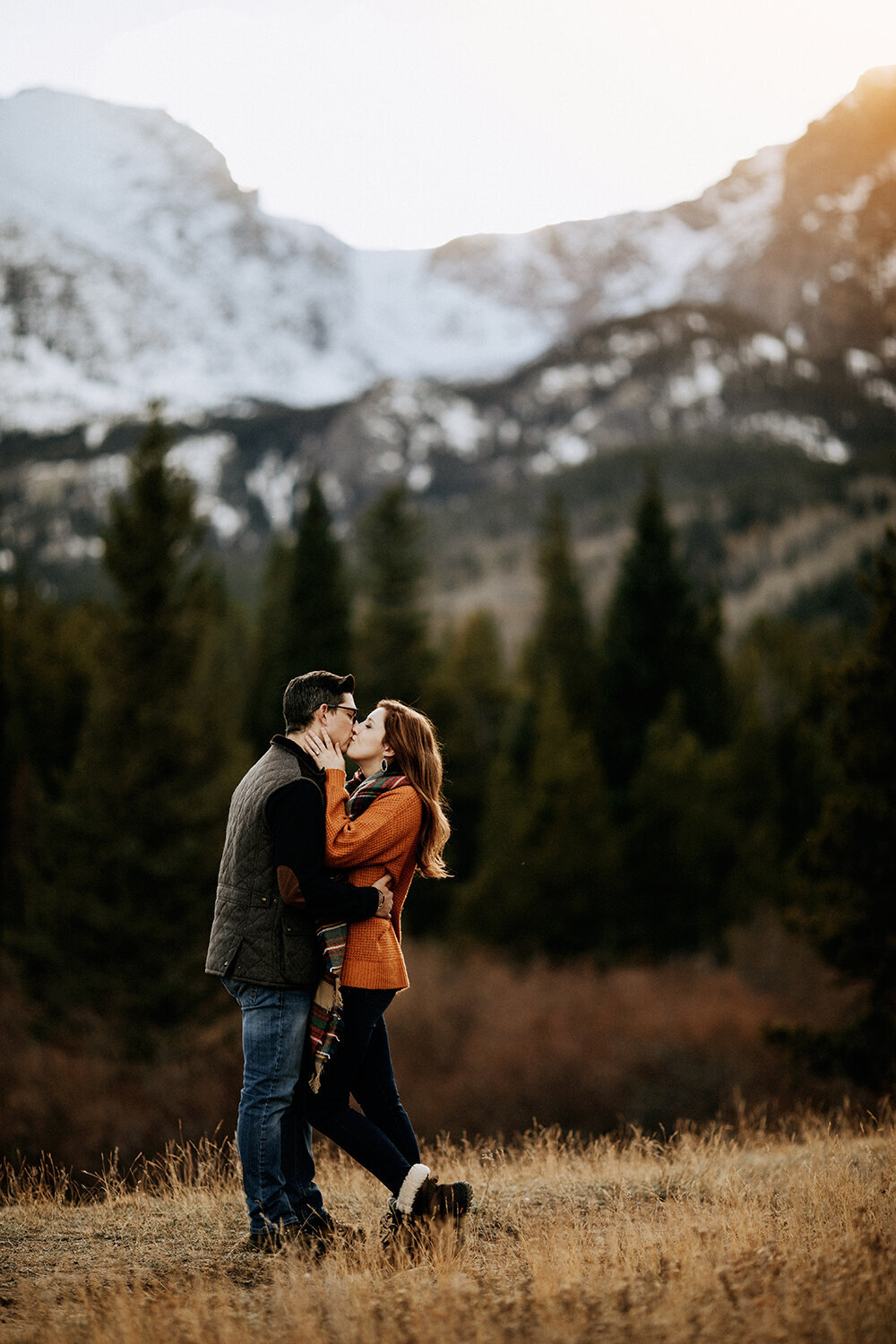 Family Photography, couple kissing with mountains in the background