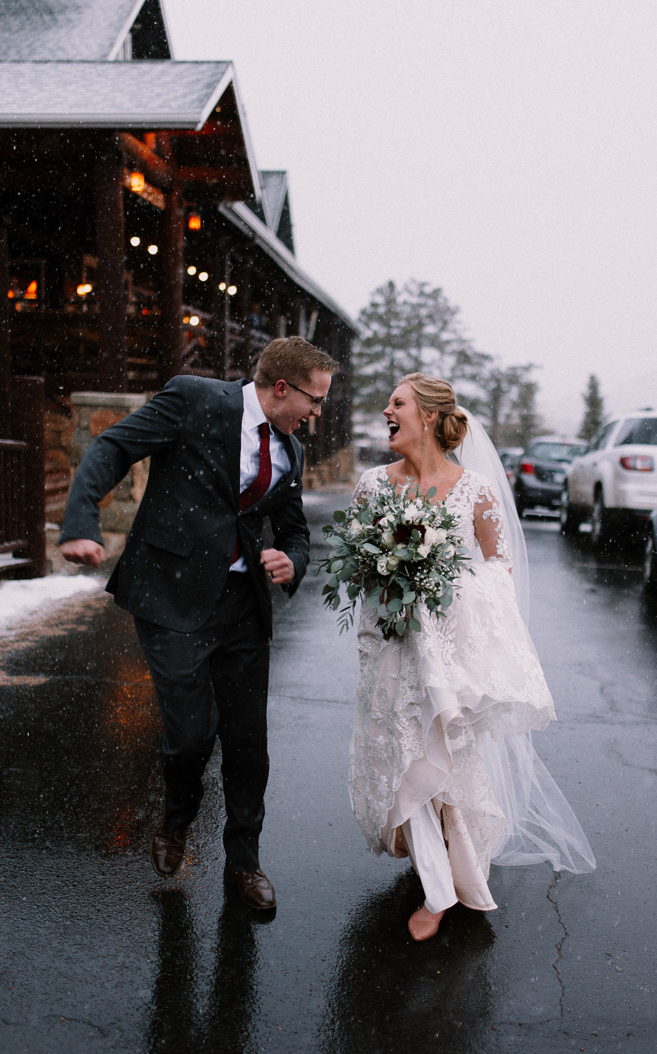 Bride and groom running through the snow in Estes Park Colorado