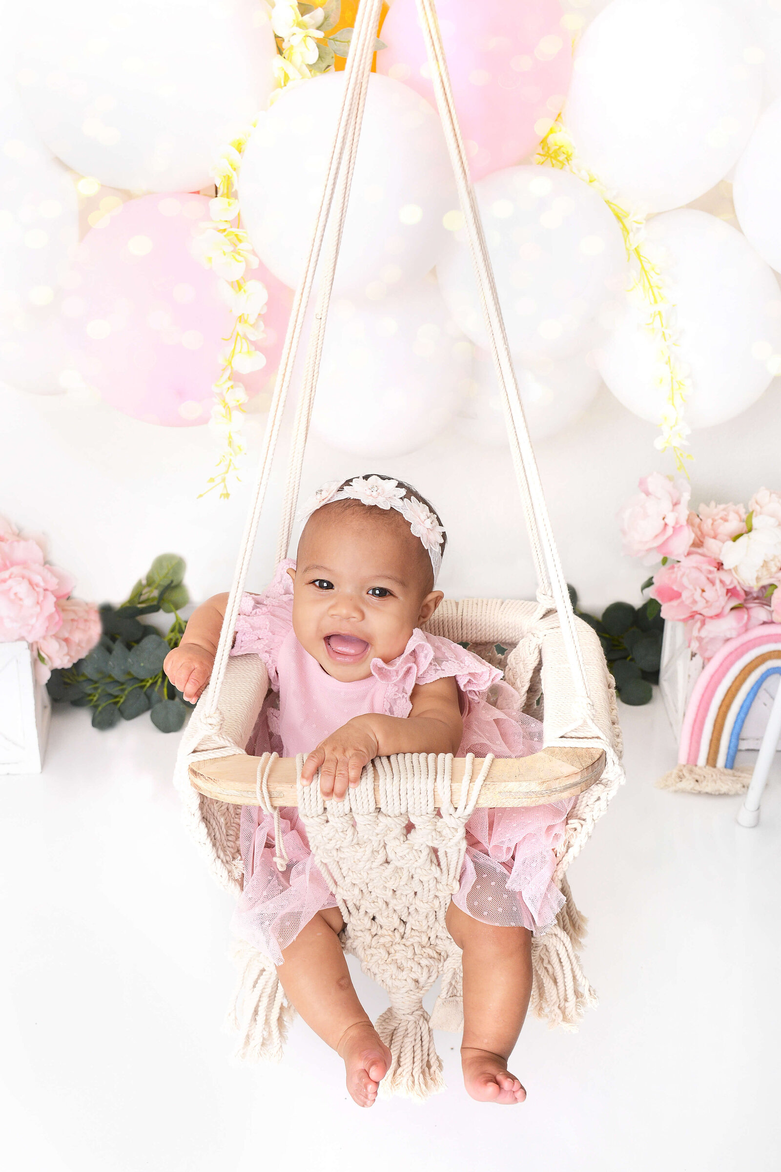 girl smiles in a swing at a photo studio in houston