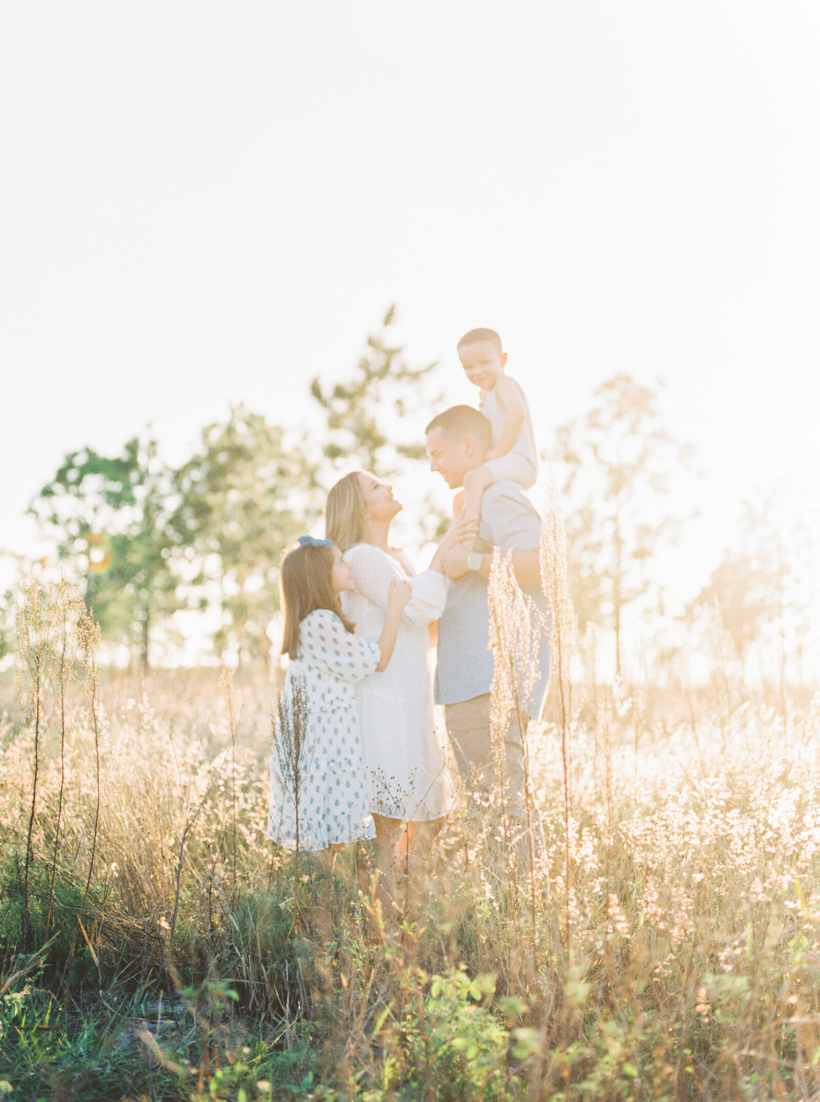 family in the field soaked in sunlight with Orlando family photographer