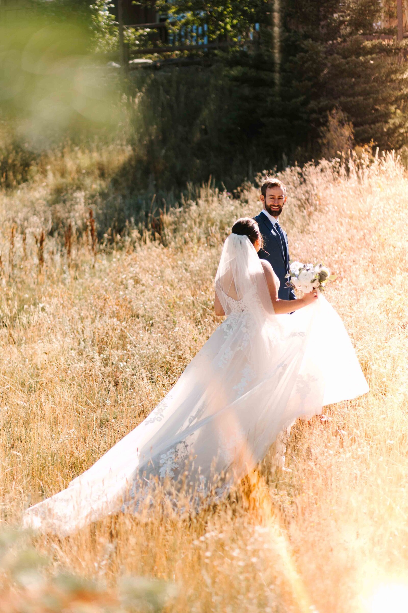 Bride holding her floral bouquet facing the groom while walking  happily in an outdoor area