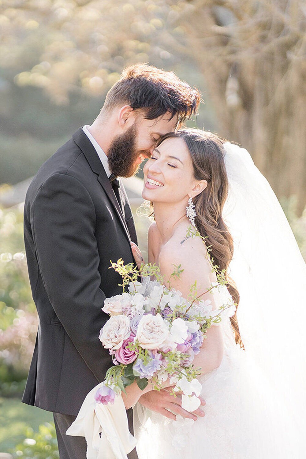 A bride and groom smile and laugh in front of the fountain at Elliston Vineyards by Adrienne and Dani Photography