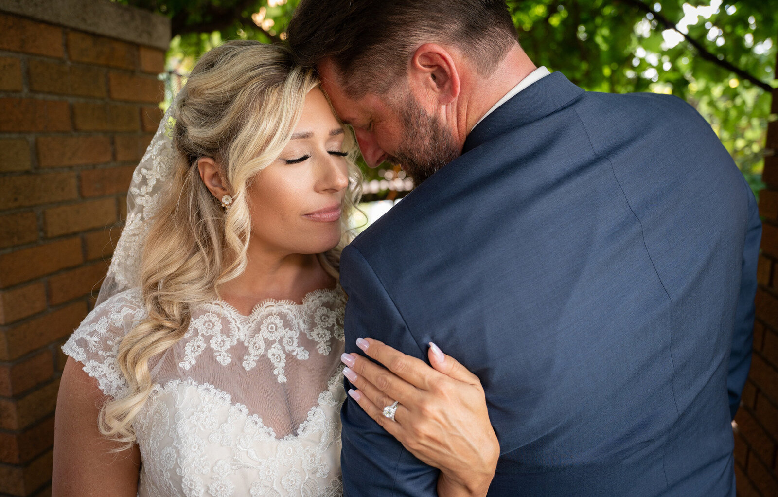 bride hold grooms arm and close their eyes