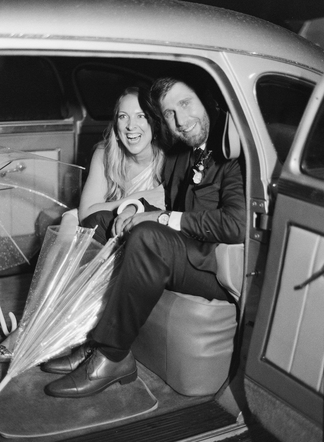 black and white of bride and groom getting in getaway car