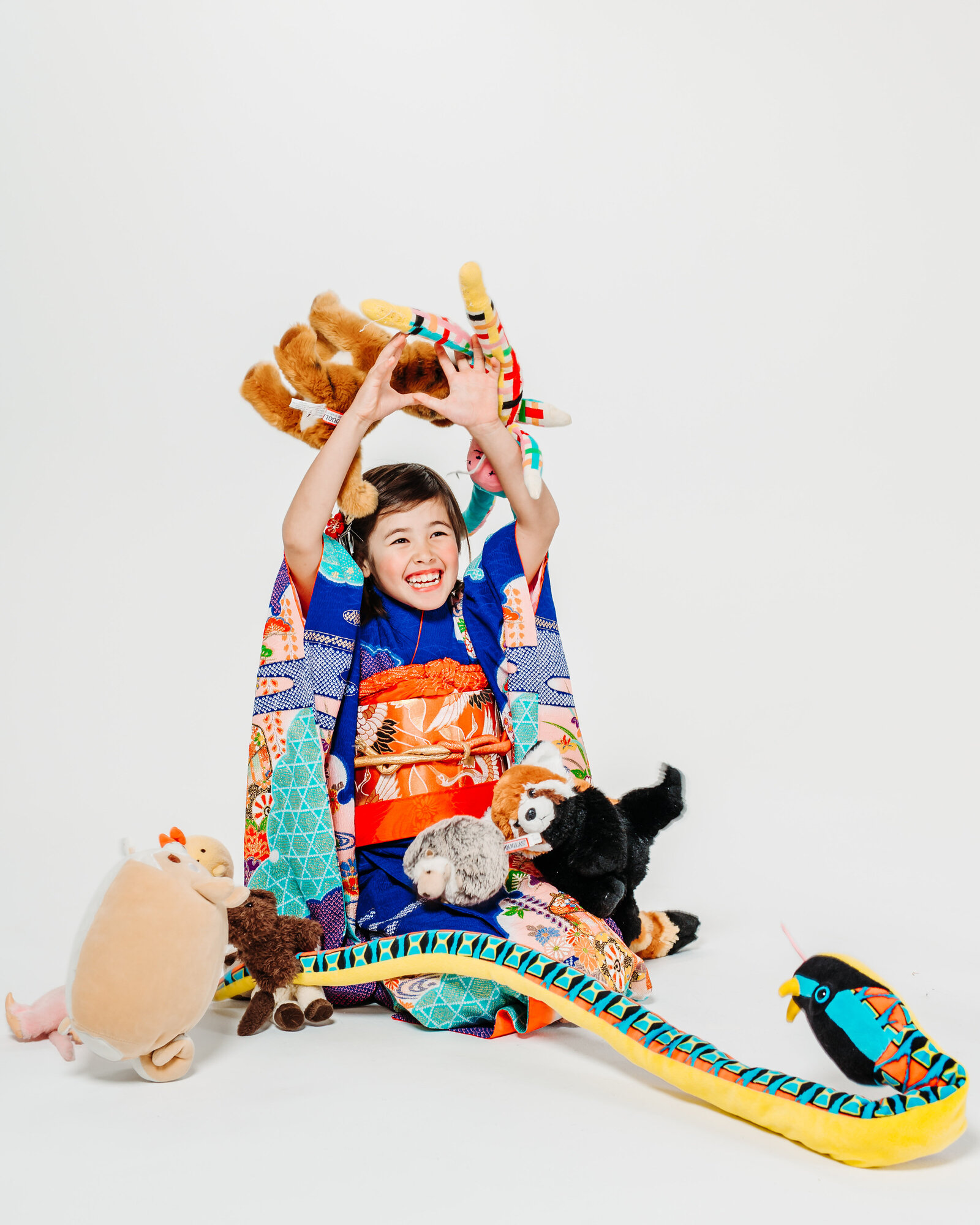 Girl in vibrant kimono smiling at photo studio during Shichi-Go-San celebration | 七五三 スタジオ 色鮮やかな着物で微笑む女の子