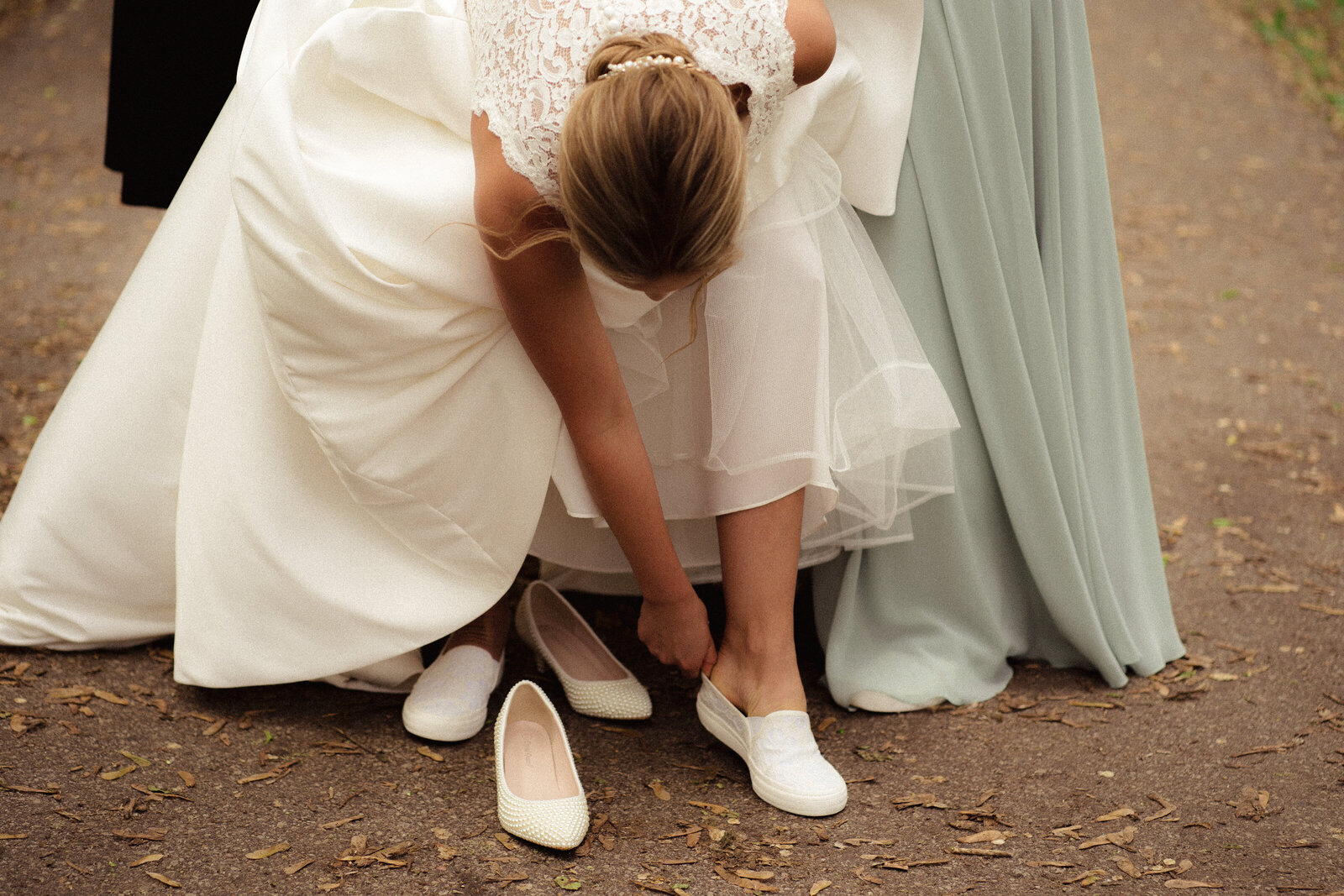 bride exchanges jimmy choo heels with white TOMS shoes
