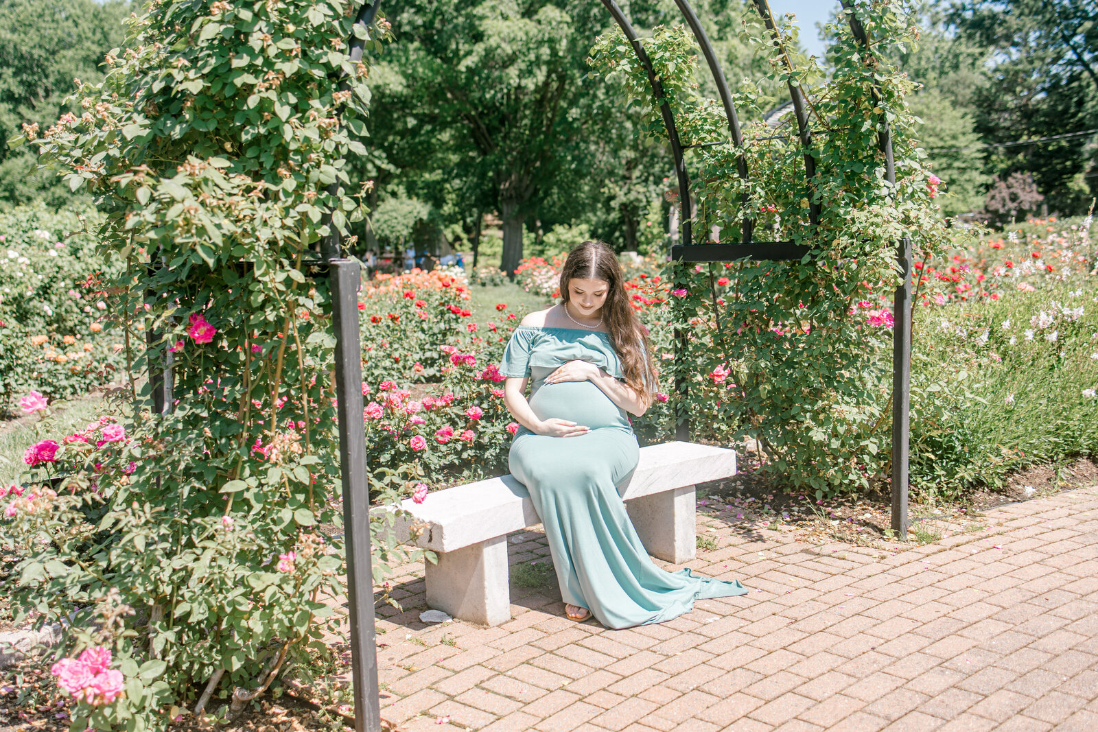 Pregnant woman sitting on a bench in a garden