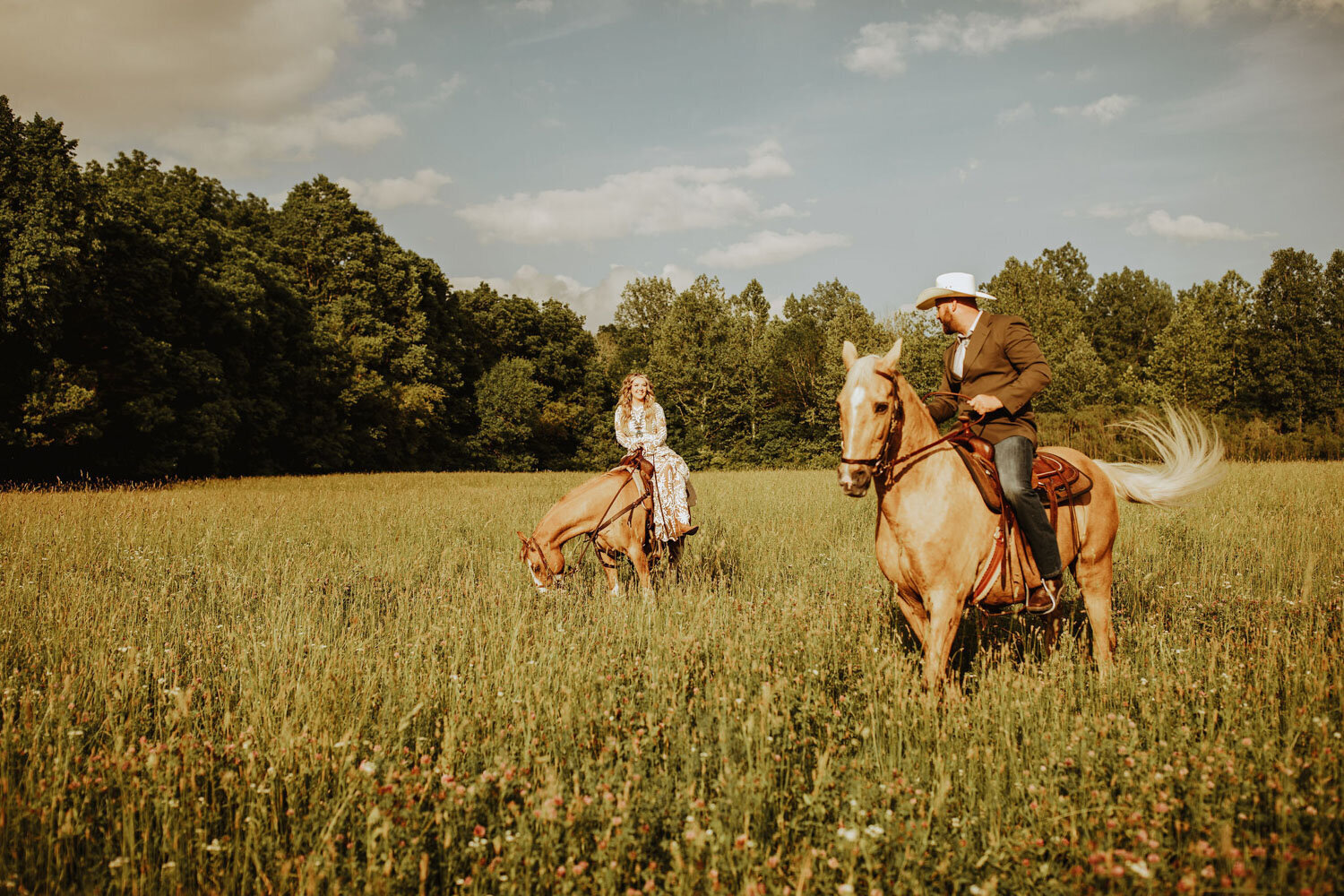 Bride and groom on horseback in an open field