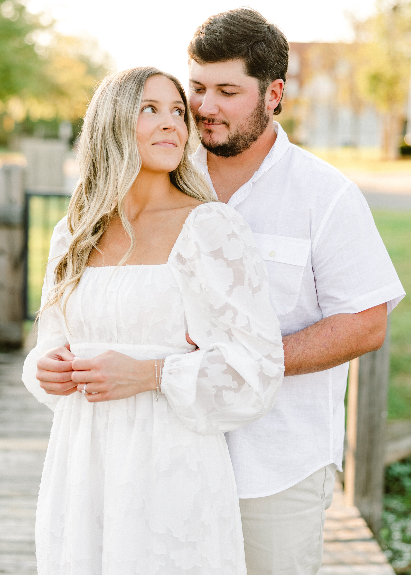 Kelby and Mason posing in front of a rustic barn, captured by Abby Bell Photography. Romantic and personalized engagement photography in Alabama.