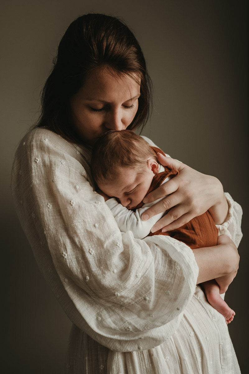 moeder knuffelt slapende baby