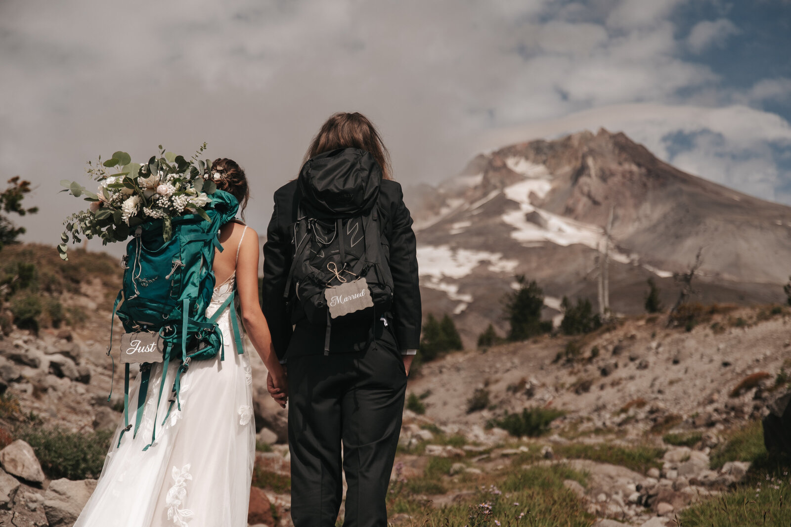 Eloping couple walks hand in hand in front of majestic Mt. Hood during a scenic Portland Oregon mountain elopement captured by a local wedding photographer.