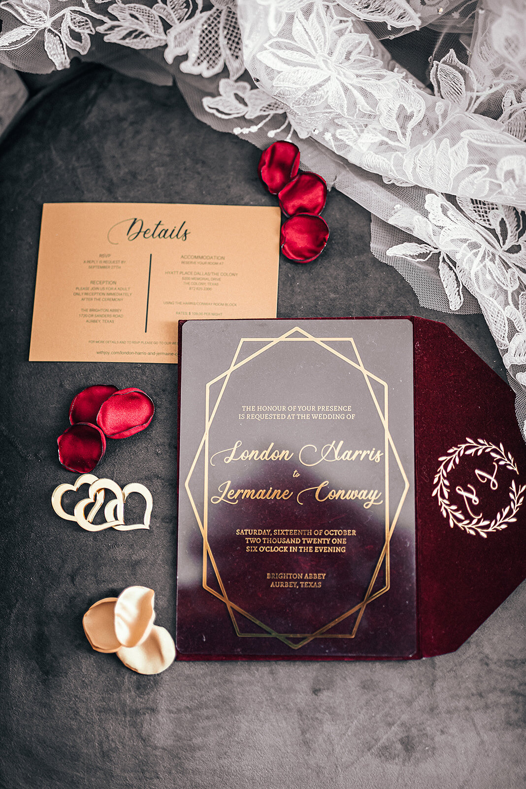 Deep red and gold wedding invitations with rose petals and lace