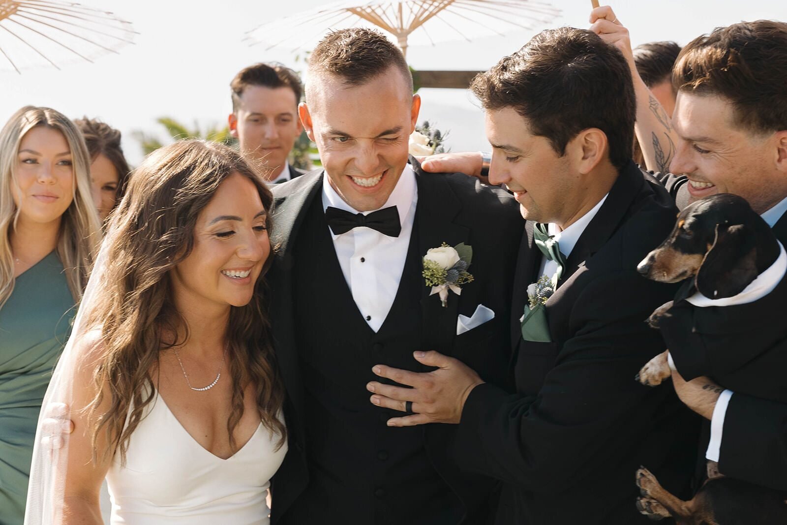 Bride and groom laughing with their wedding party