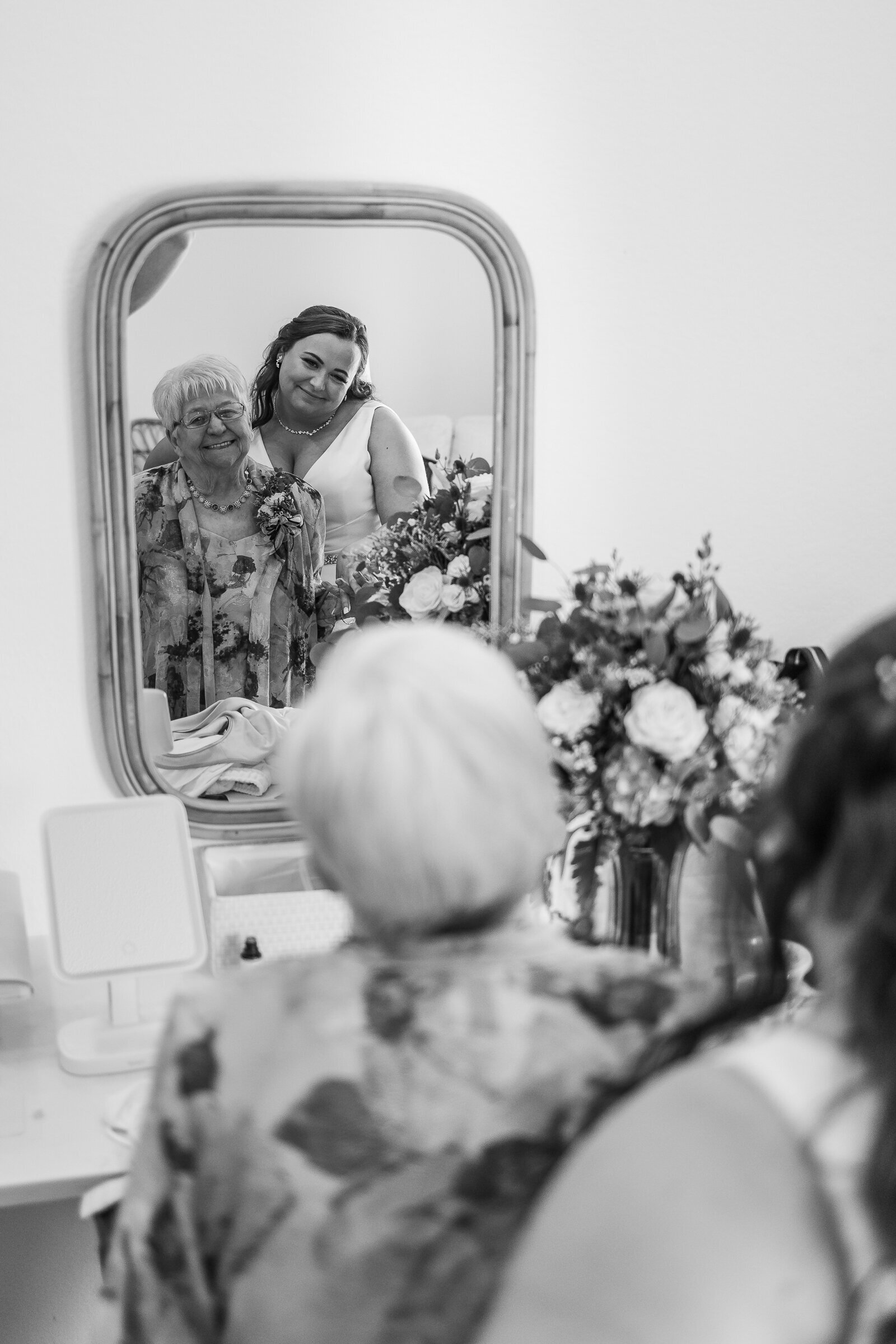 Bride poses for a photo in the mirror with her grandmother