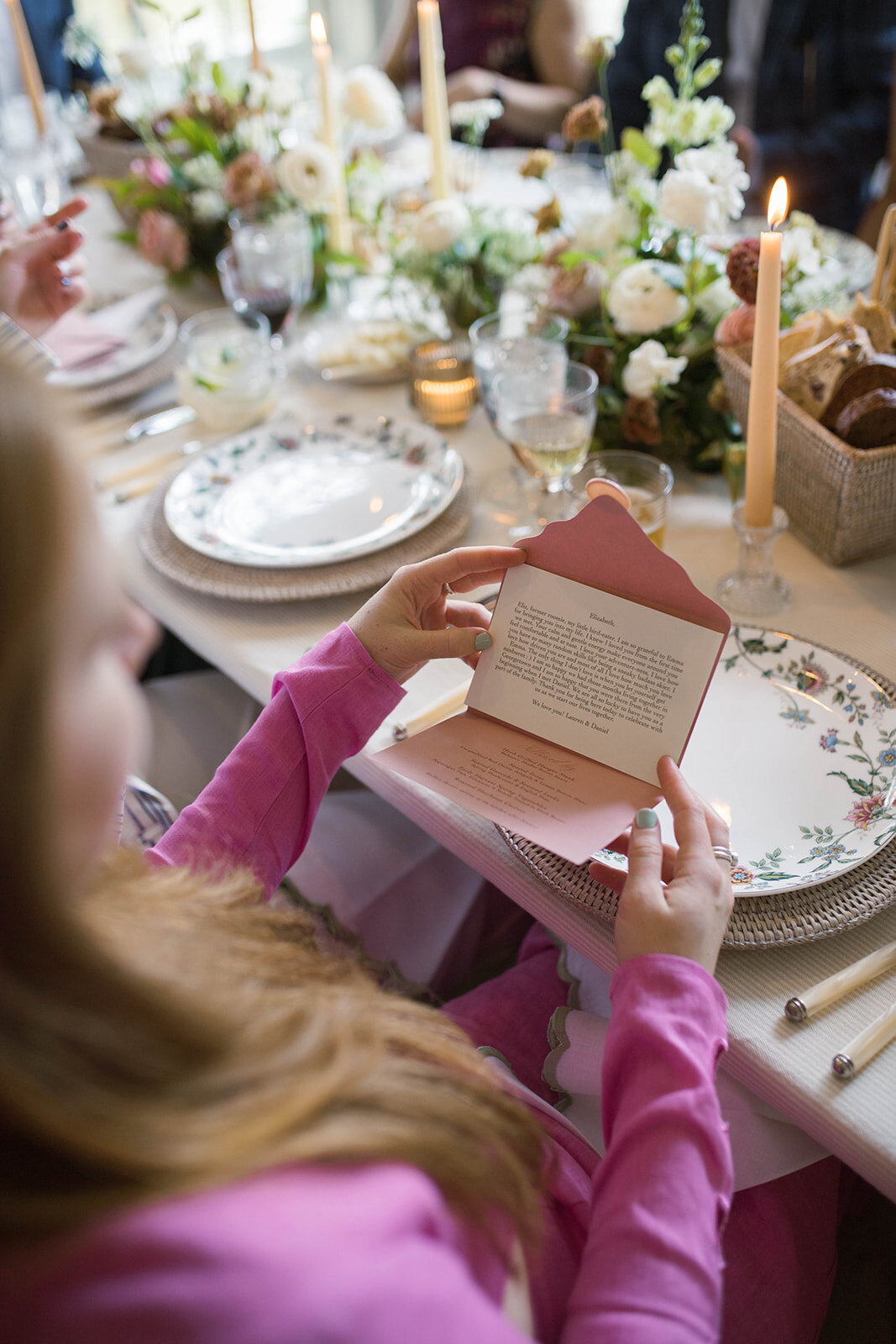 Wedding guest reading personalized table setting note from the bride and groom.