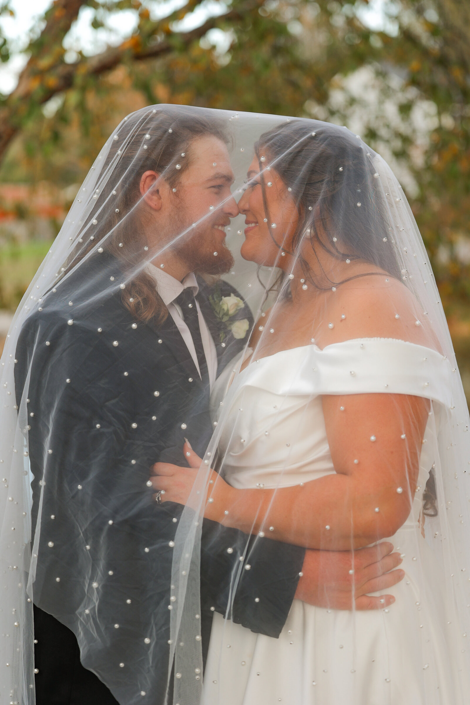 Bride and Groom  hugging under pearl veil by Columbus Georgia Wedding photographer Amanda Richardson Photography