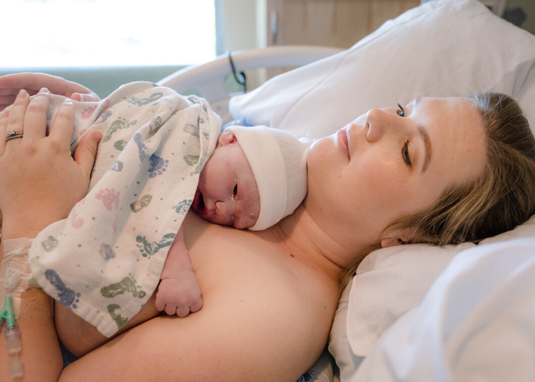 A new mother relaxes during skin-to-skin time with her new baby. Birth story by Diane Owen Photography.
