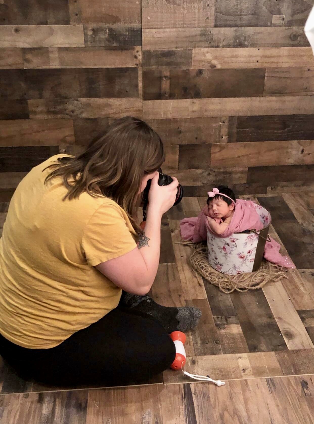 baby girl in pink bucket, newborn photographer taking picture