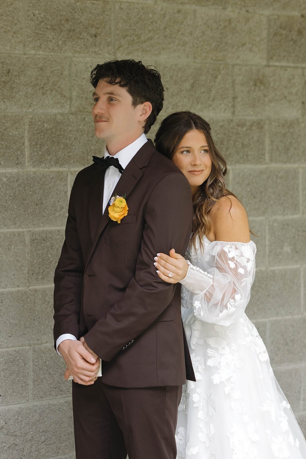 Bride leaning on the groom's shoulder during their first touch