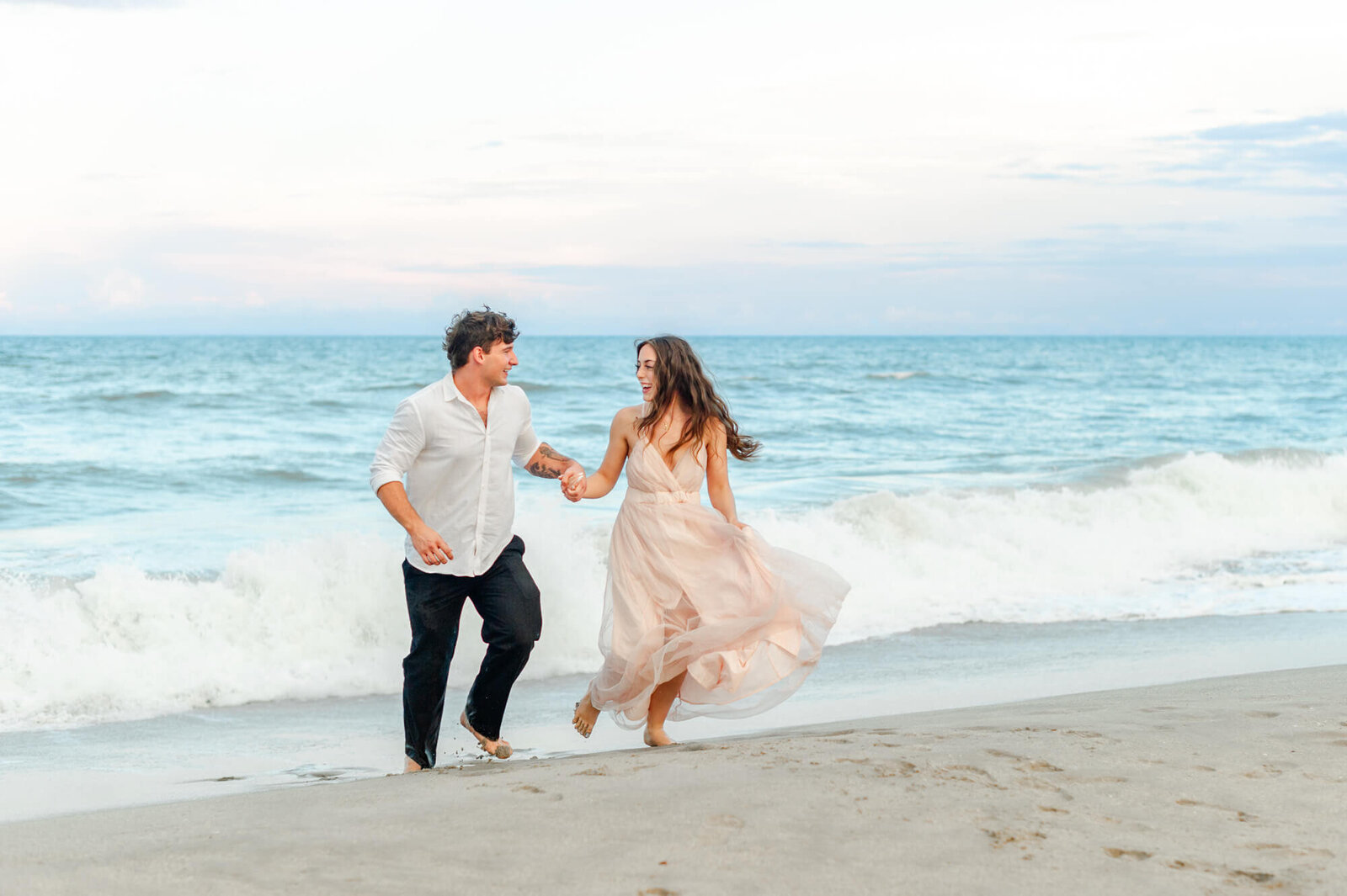 Couple running on the beach during their couples photography session