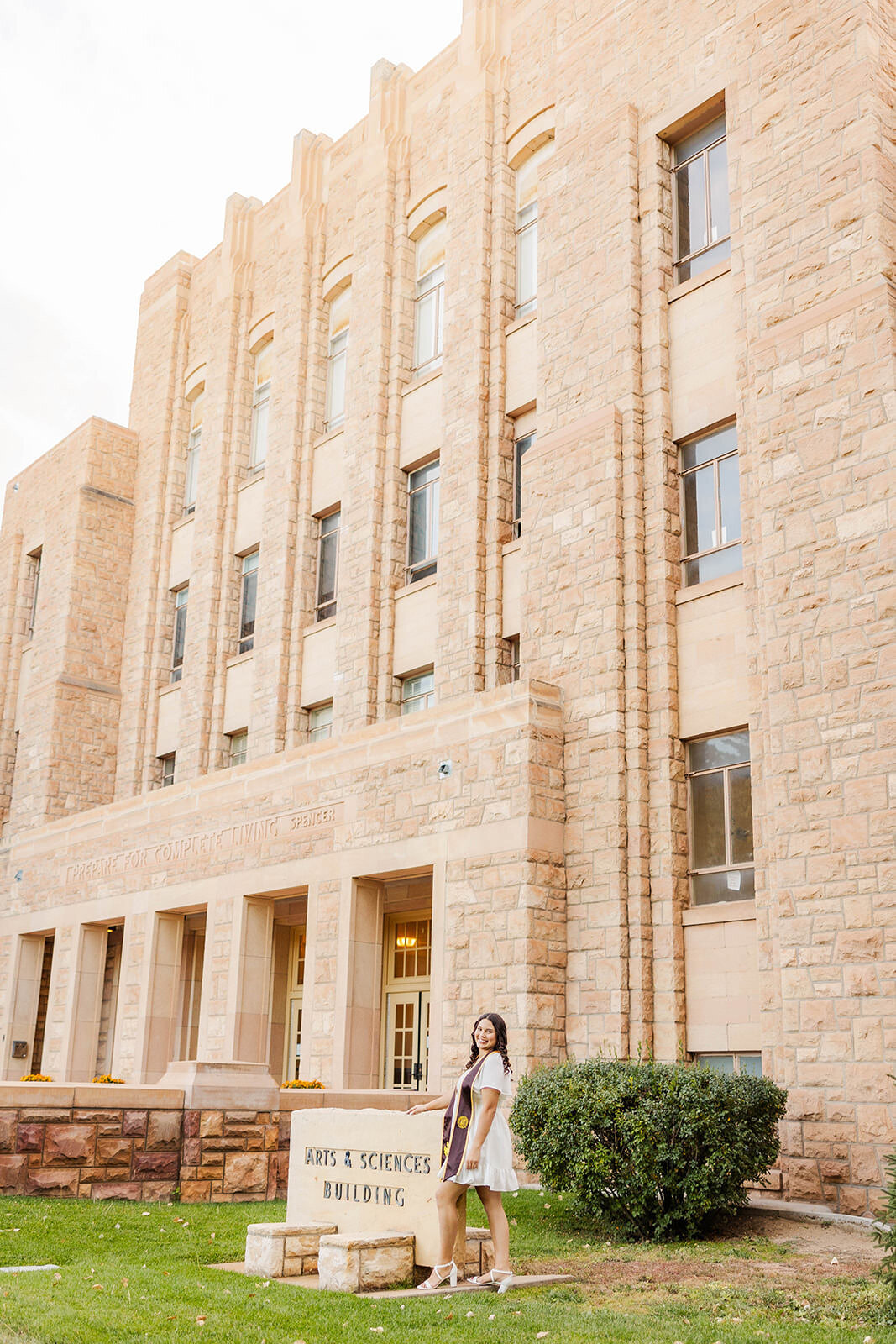 College graduate posing for her graduation photos at the University of Wyoming.