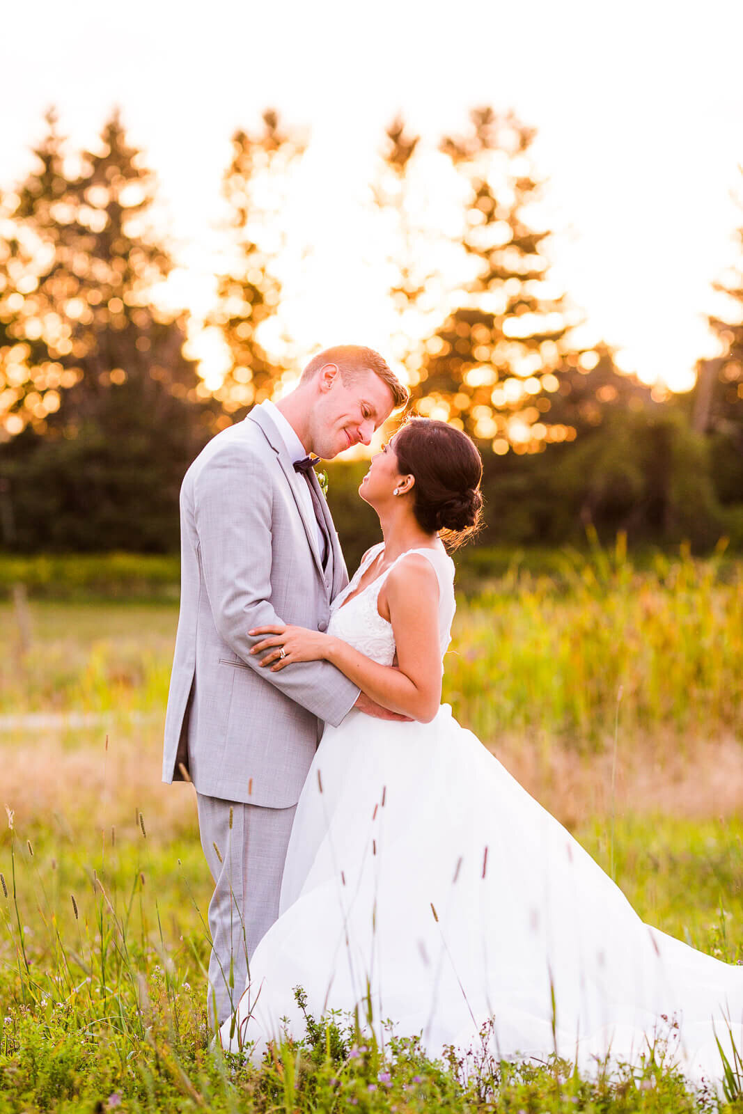 Bride and groom embrace at sunset in field at The Clearing near London Ontario.