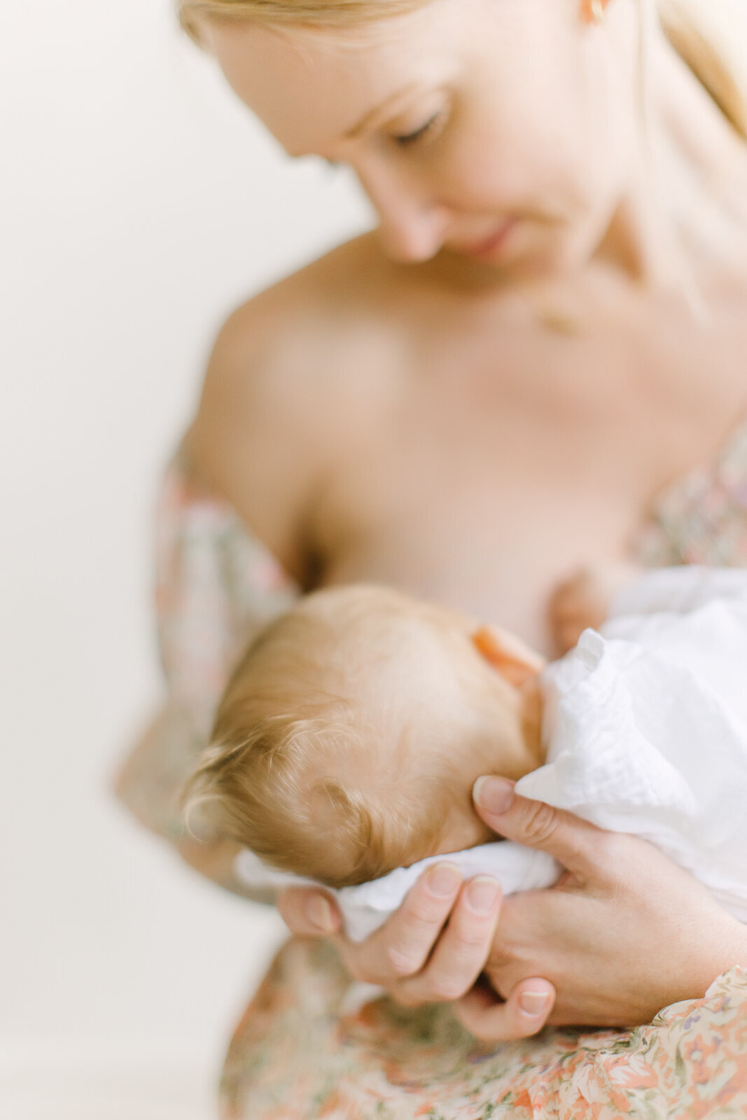 A close up image focusing on an infant's head while his mother breastfeeds him during photo session with Boston family photographer Corinne Isabelle