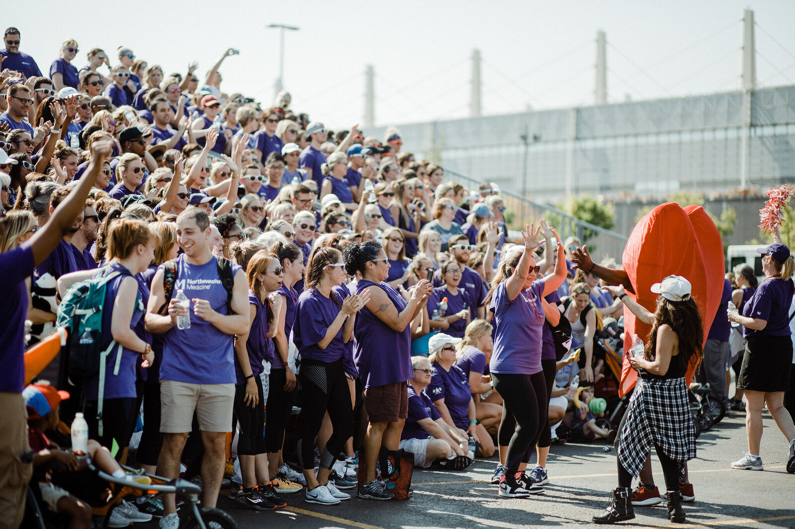 Crowd in purple shirts cheering outdoors