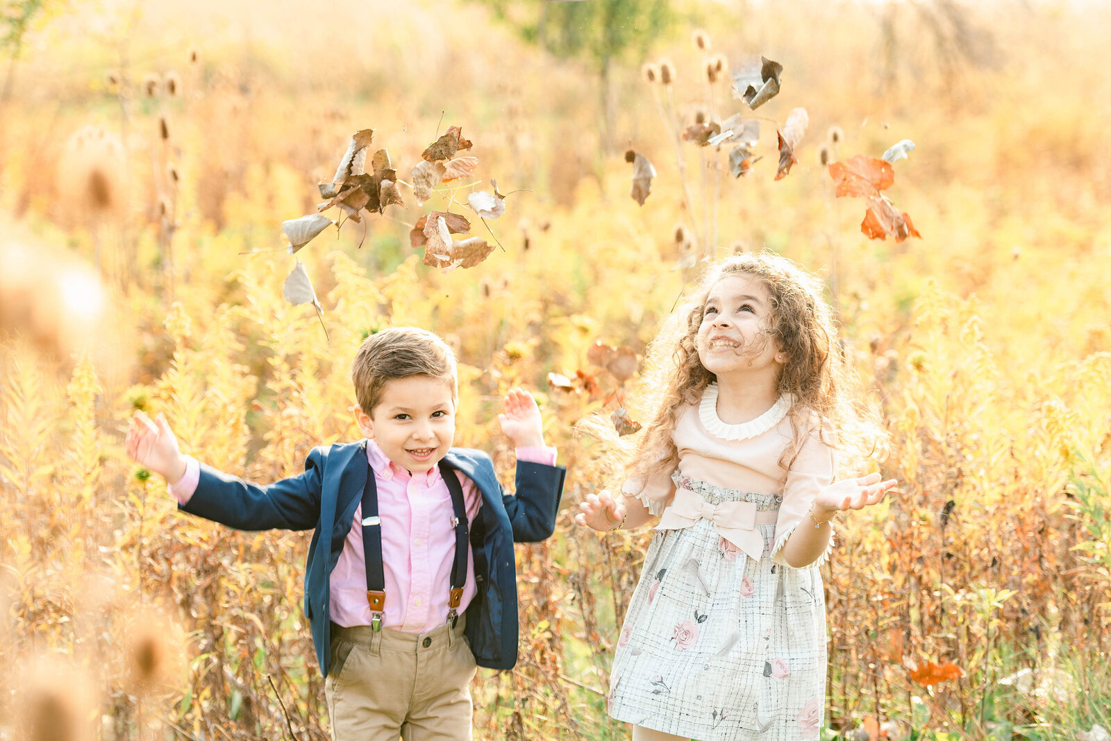 A young brother throw leaves at their Chicago family photos