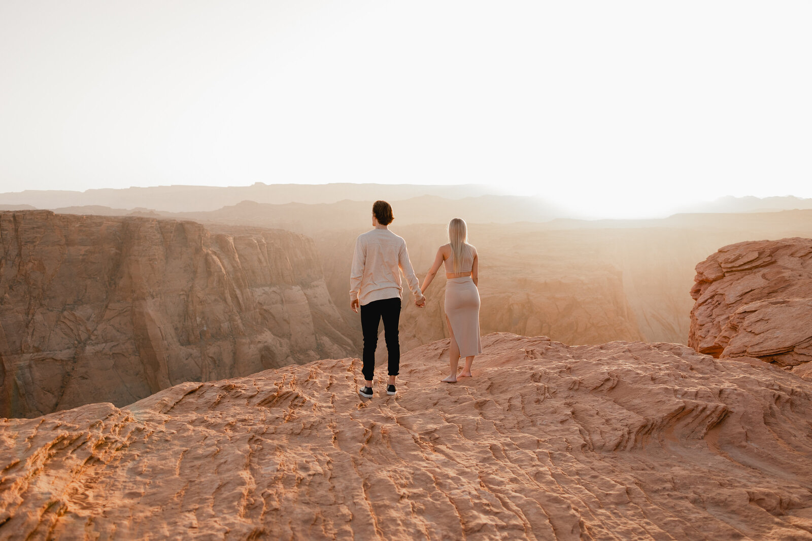 couple holding hands during golden hour at Horseshoe Bend in Page Arizona during couples session