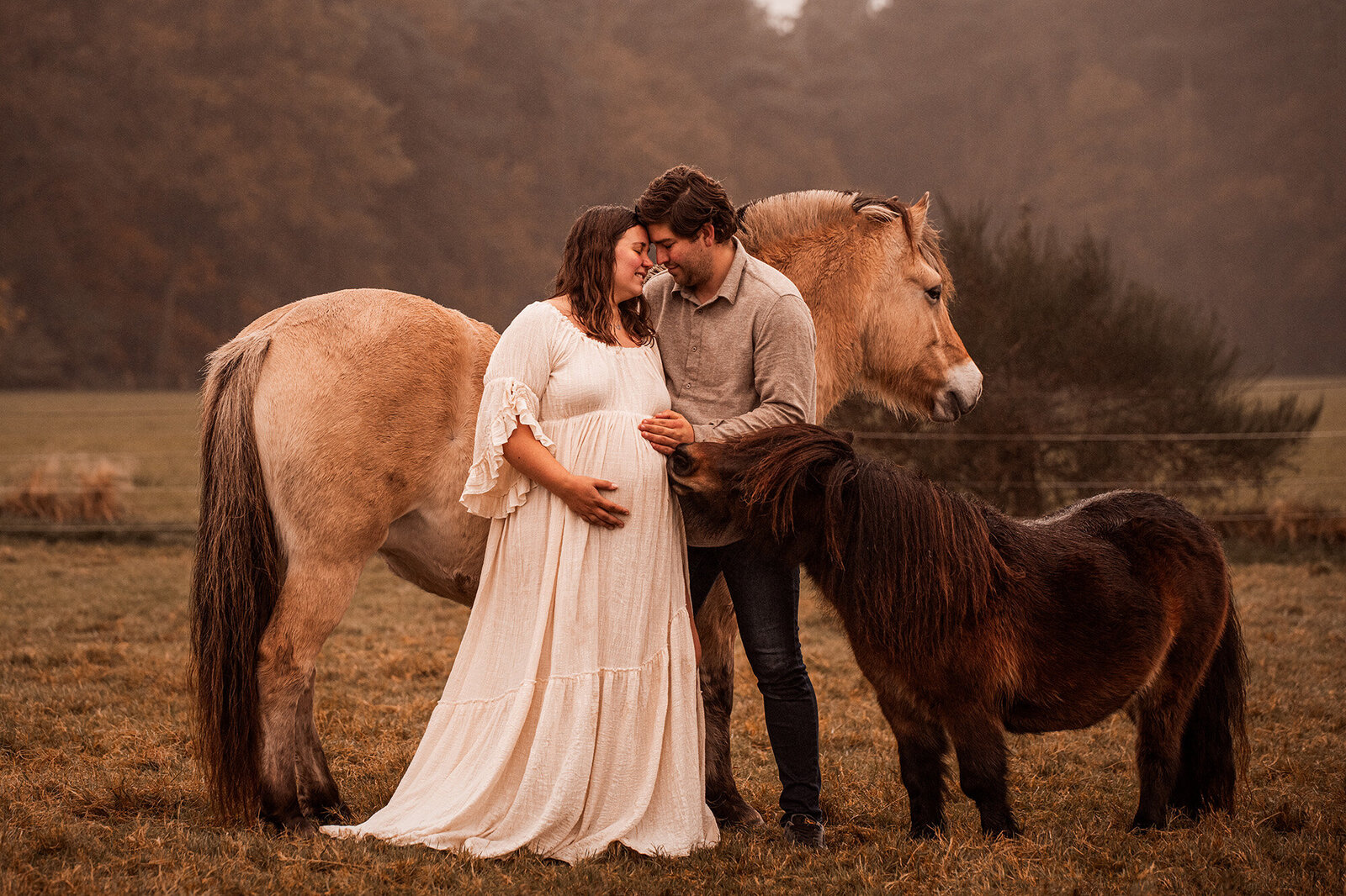 Een stralende aanstaande moeder poseert met haar paard in een rustige, natuurlijke setting, die de bijzondere band tussen hen en de verwachting van nieuw leven vastlegt