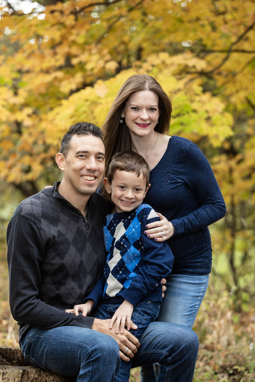 A man and woman are posing for a picture with their son