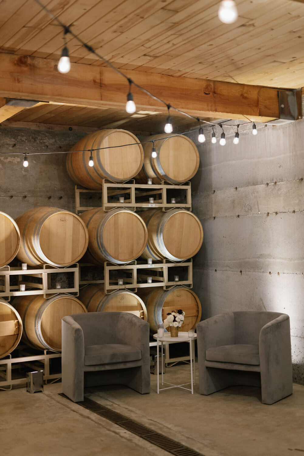 Barrel-lined wine cellar with lounge chairs