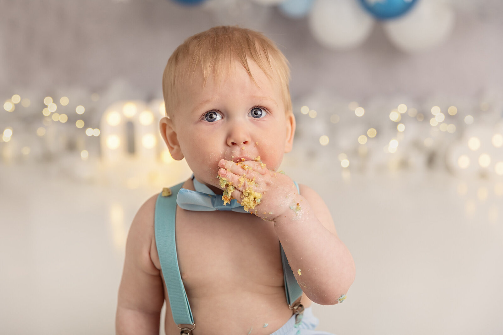 close up of baby boy eating cake by milestone photographer new philadelphia