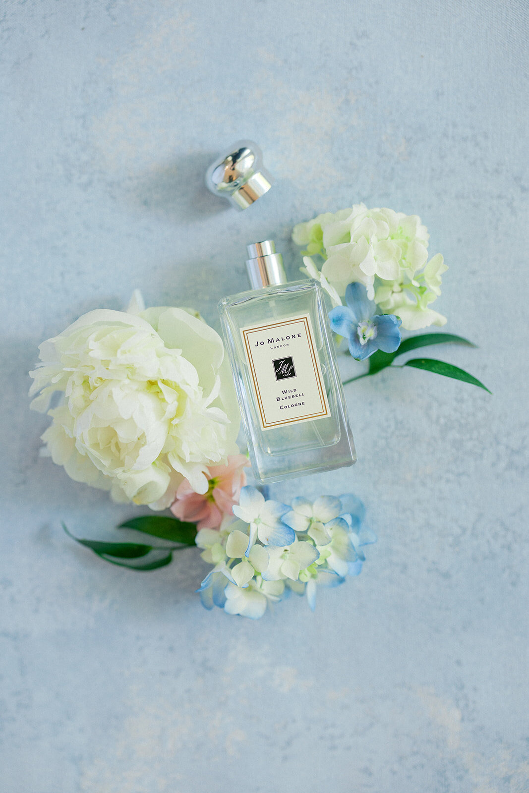 perfume on blue background with flowers