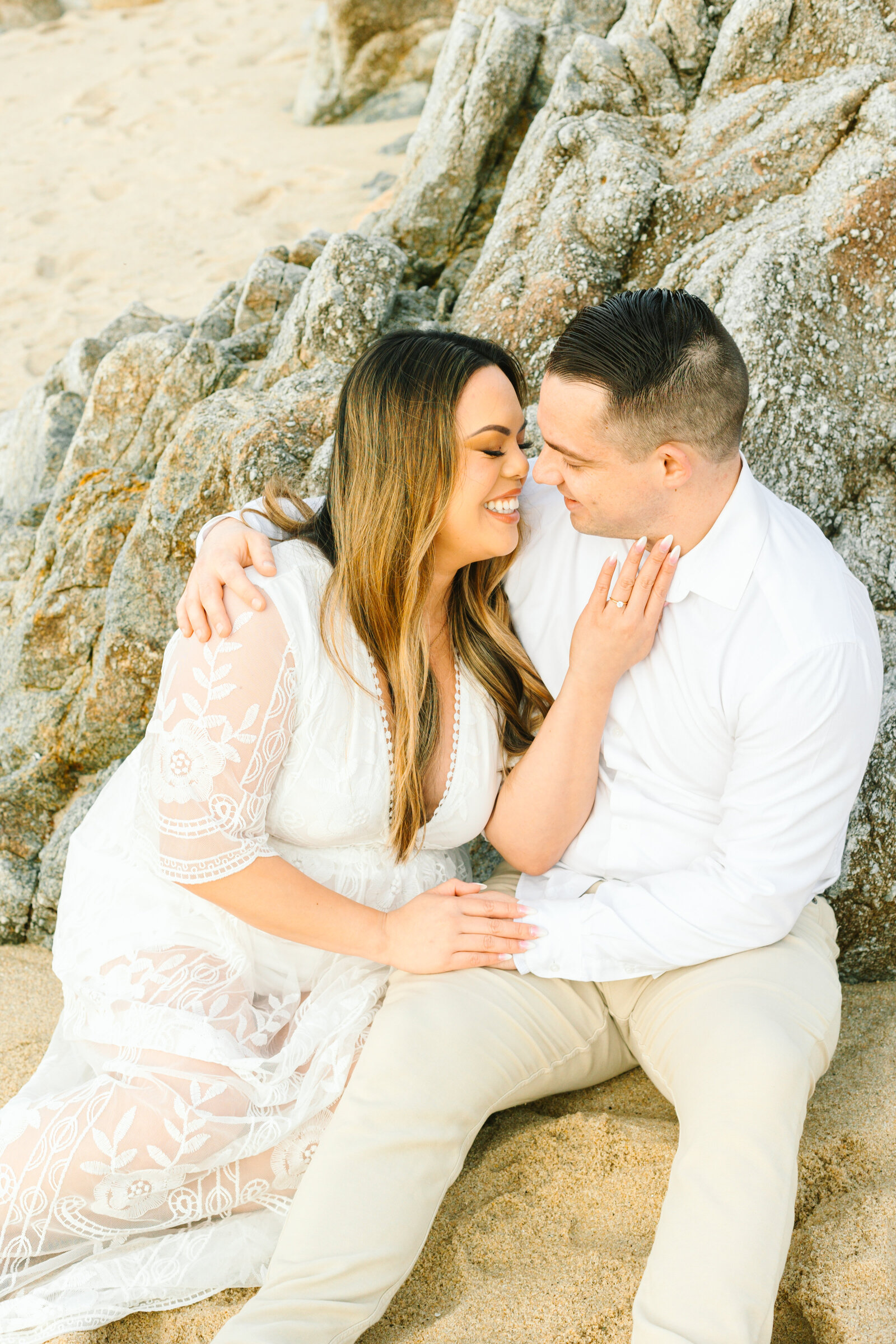 An engaged man and woman take photos on the beach in Pacific Grove, Monterey, California near Big Sur.