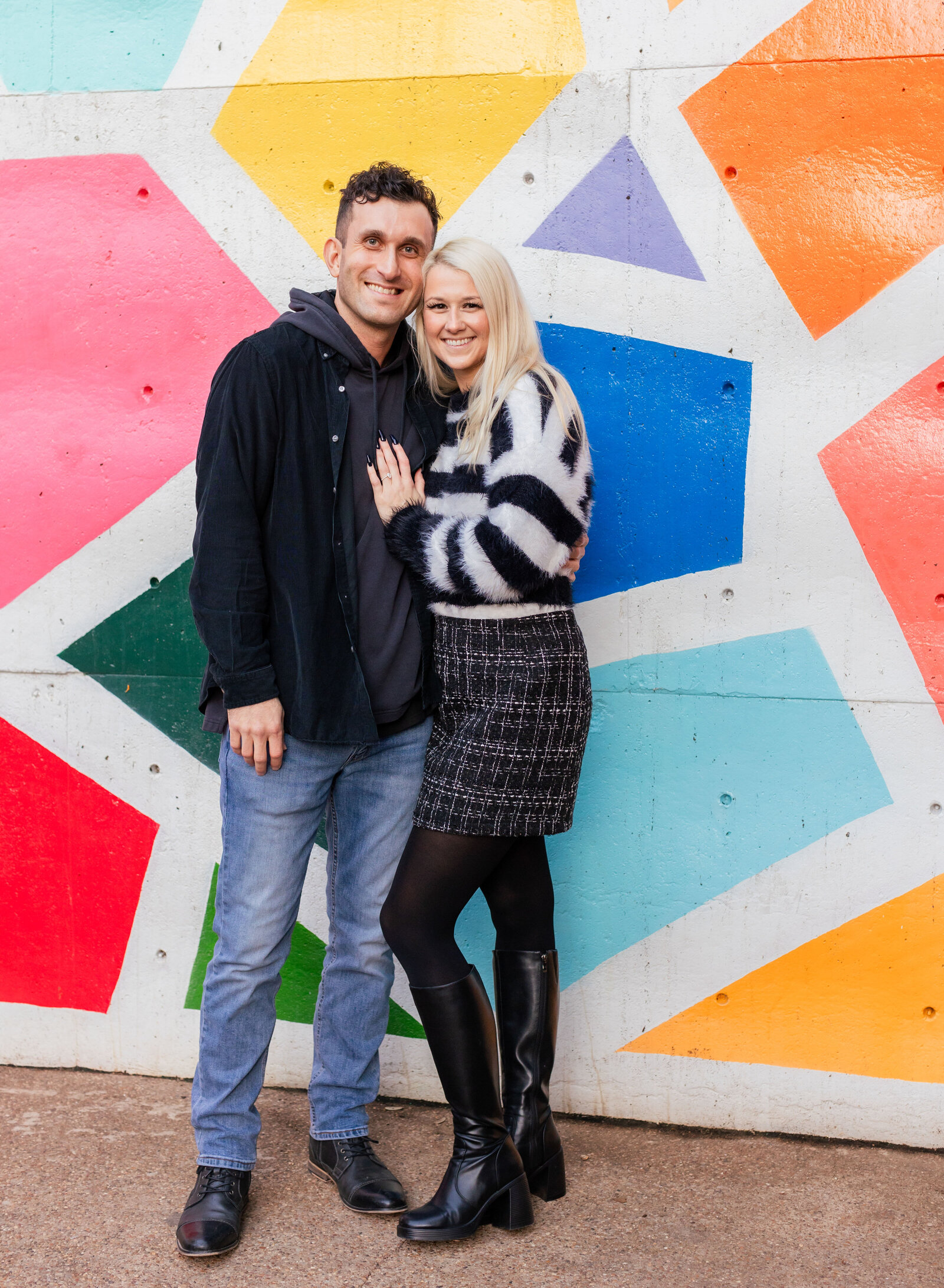 happy couple in front of colorful mural